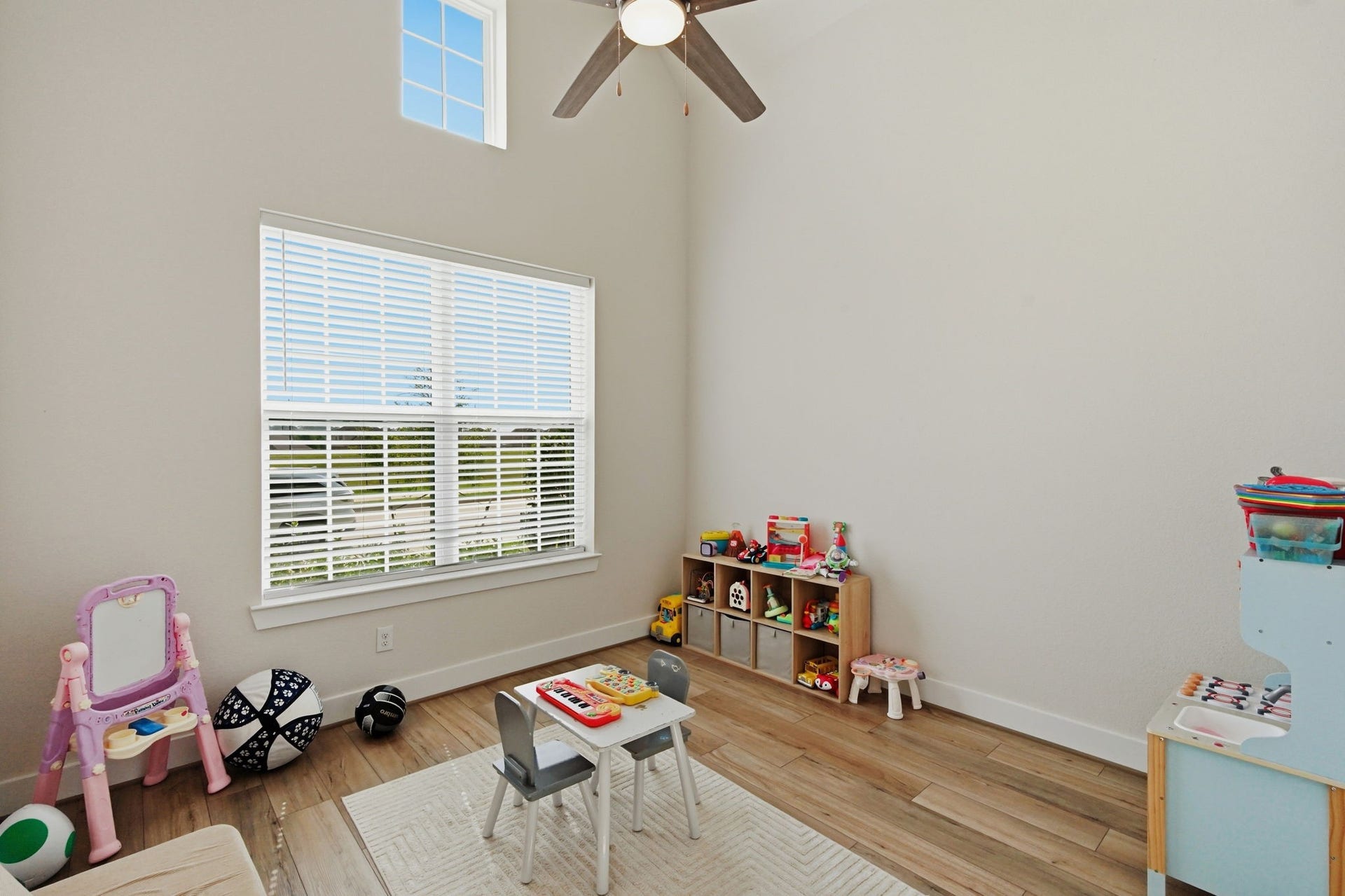 24615 Lukes Landing Way, Tomball, TX 77375 Bright and airy playroom or Home office featuring high ceilings, abundant natural light from large windows, and ample space for toys and activities.