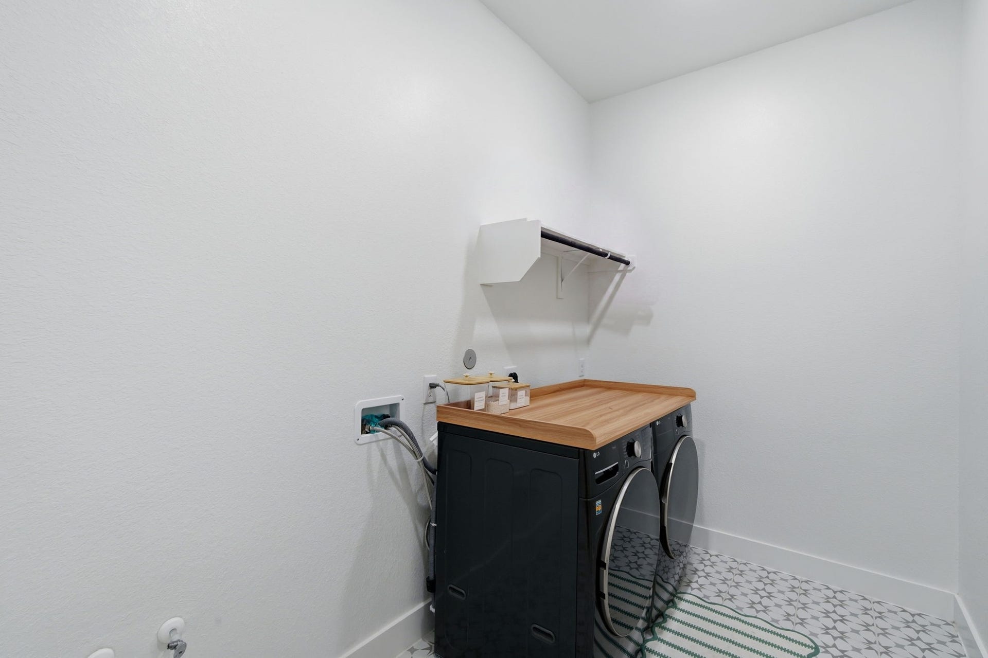24615 Lukes Landing Way, Tomball, TX 77375 Modern laundry room featuring sleek appliances, a wooden countertop, and stylish patterned flooring, offering a functional and inviting space for chores.