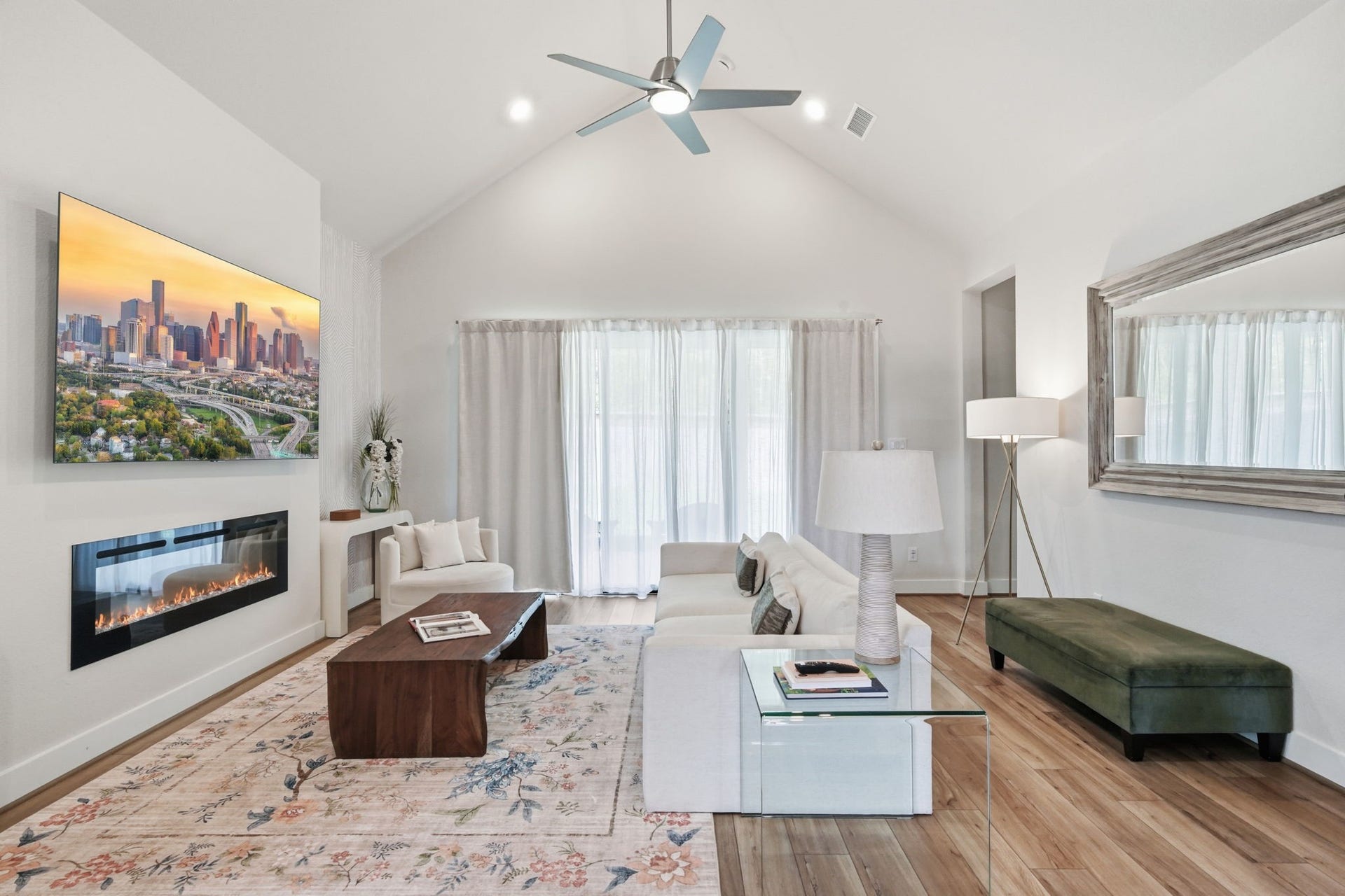 24615 Lukes Landing Way, Tomball, TX 77375 Discover a bright and inviting living room featuring high ceilings, a sleek modern fireplace, and an expansive window that bathes the space in natural light.