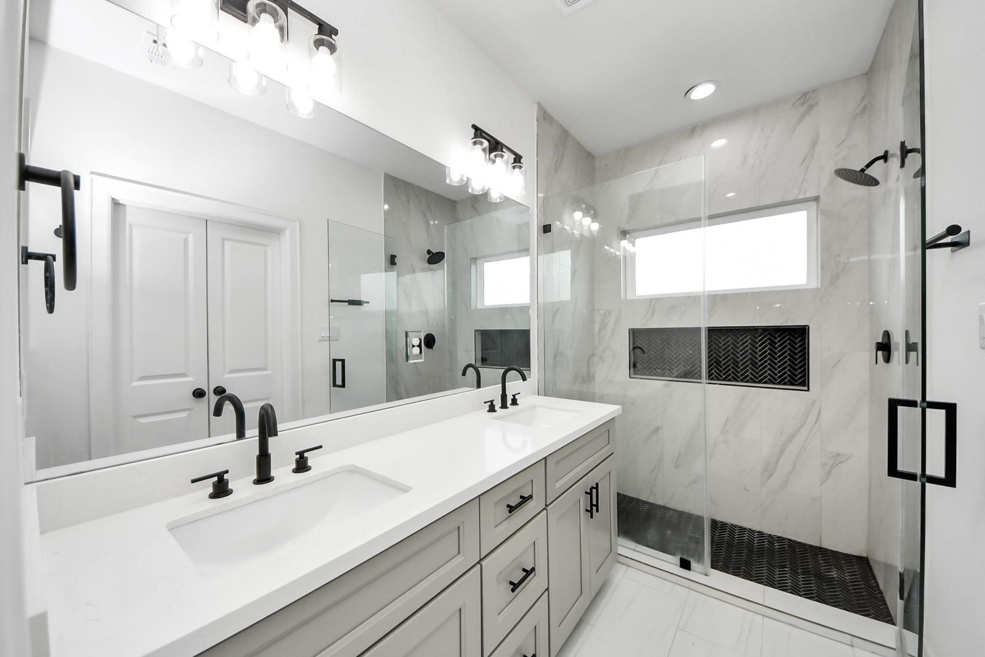 8316 Corinth Street, #c, Houston, TX 77051 A frameless glass walk-in shower with marble-look tile and black herringbone accents makes a bold design statement.