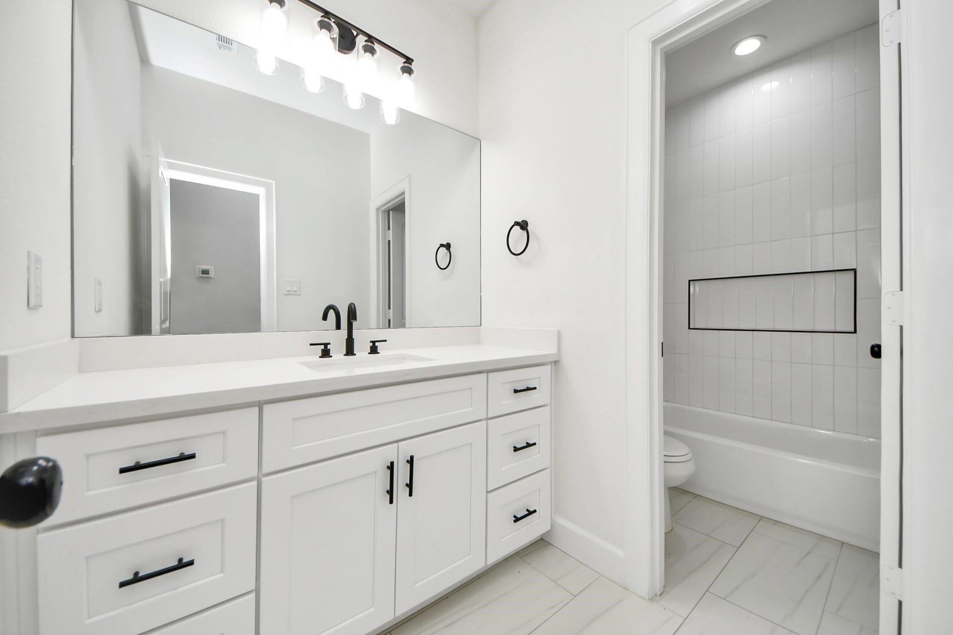 8316 Corinth Street, #c, Houston, TX 77051 This full bathroom features a quartz-topped vanity, designer black hardware, and ample under-sink storage.