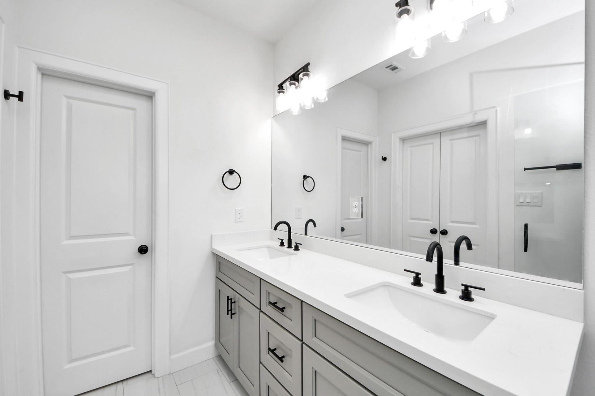 8316 Corinth Street, #c, Houston, TX 77051 Designer-selected lighting fixtures and full-length mirror elevate this primary bath's functionality and style.