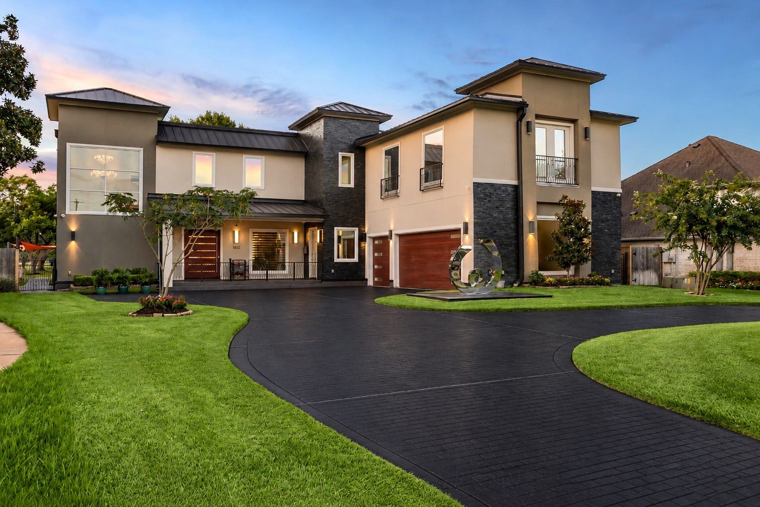 A distinctive composition of contemporary architectural lines, contrasting exterior finishes, expansive windows, and carefully positioned exterior lighting. The sweeping circular driveway provides an impressive approach to the residence and its attached three-car garage.
