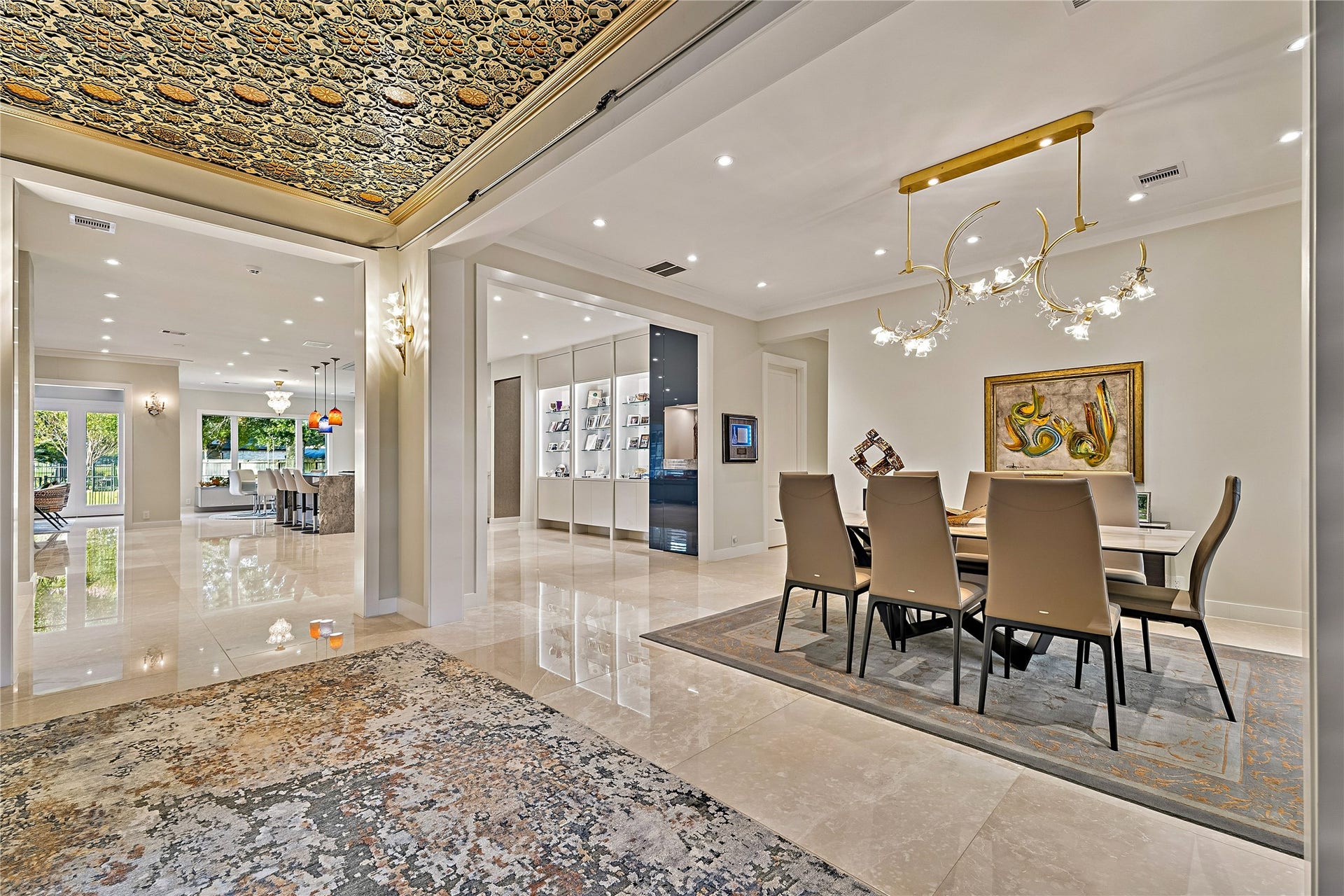 Expansive entertaining spaces featuring polished flooring, decorative ceiling treatments, statement lighting, and sophisticated architectural details. The open arrangement connects the formal dining area with the home's principal living spaces.