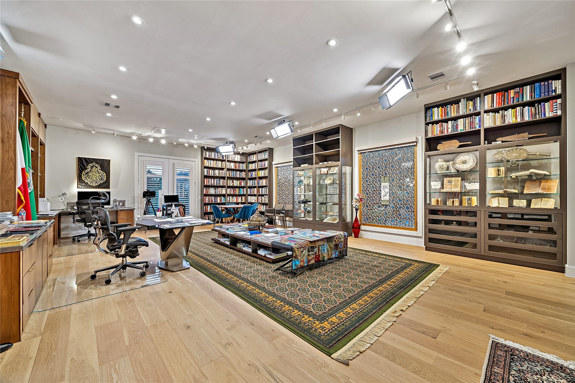 Additional perspective of the expansive private library showcasing custom bookcases, generous seating arrangements, and beautifully integrated display areas. The room's impressive dimensions accommodate multiple conversation and reading spaces.