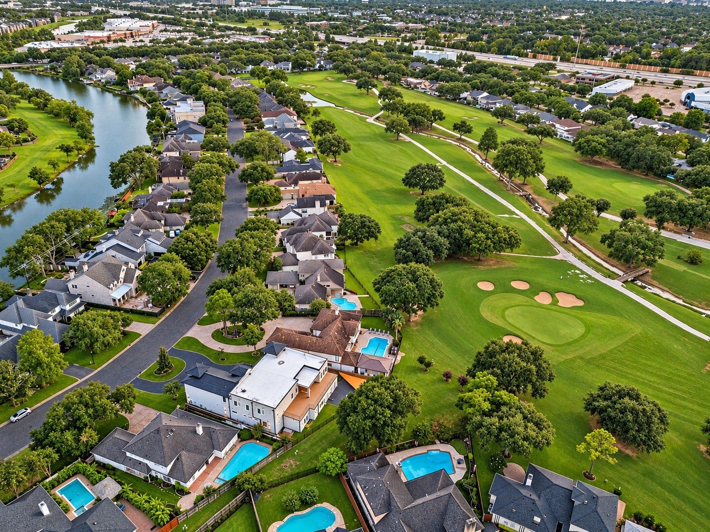 Exceptional aerial perspective showcasing the residence's direct frontage along Sugar Creek Country Club's Robert Trent Jones Sr.-designed golf course. Mature trees, beautifully maintained fairways, and the surrounding residential landscape create a picturesque setting.