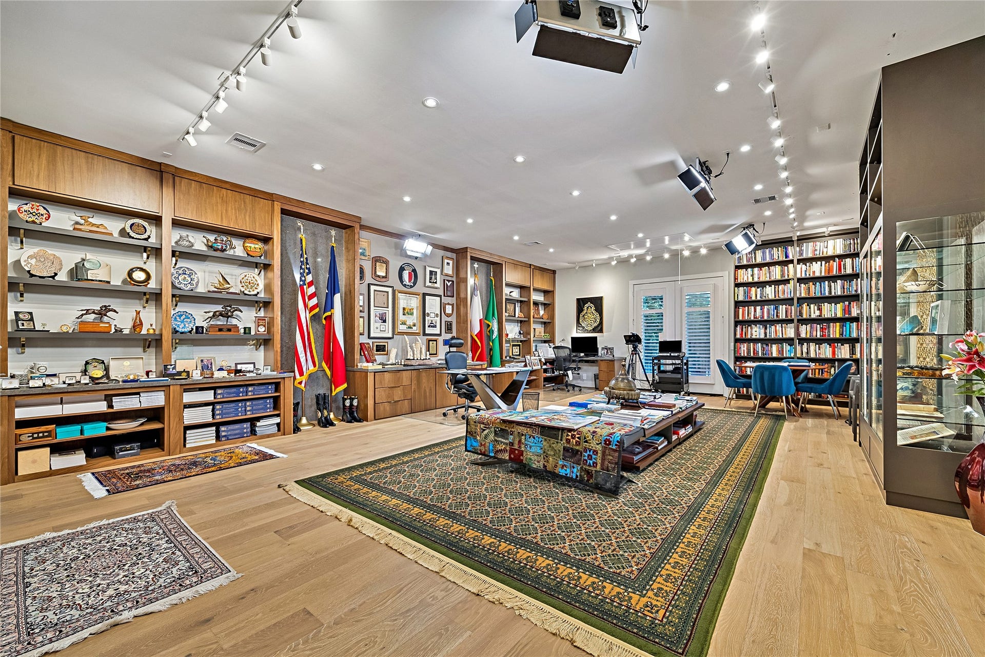 A remarkable upper-level library featuring extensive floor-to-ceiling shelving, beautifully finished wood flooring, and expansive space for reading, collecting, and entertaining. An exceptional room for showcasing a substantial book or art collection.
