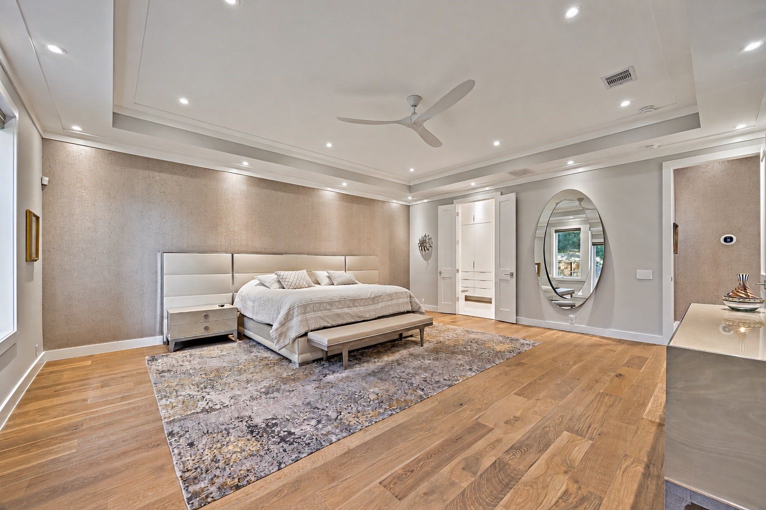 A second view of the spacious primary suite showcasing its generous proportions, elegant finishes, and thoughtfully arranged living space. The suite connects to a luxurious primary bathroom and custom walk-in closet.