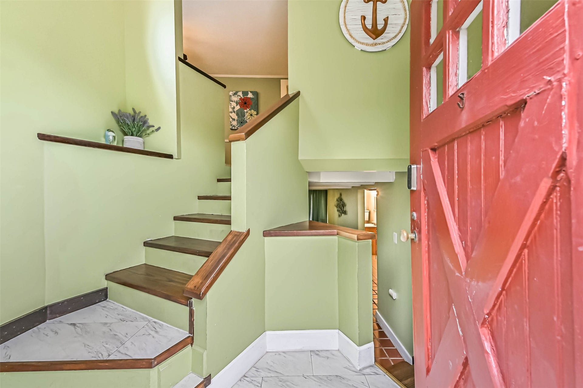 A charming entryway with a distinctive red door and stairway, adding character and visual interest to the home.