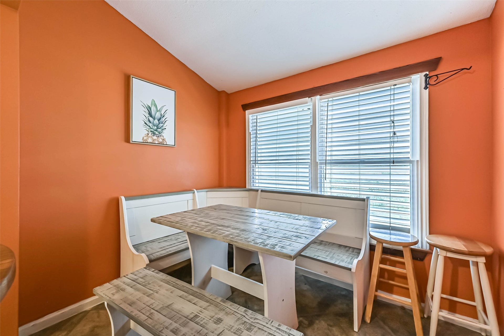 A distinctive dining area with warm orange walls and natural light, adding character to the home's interior.
