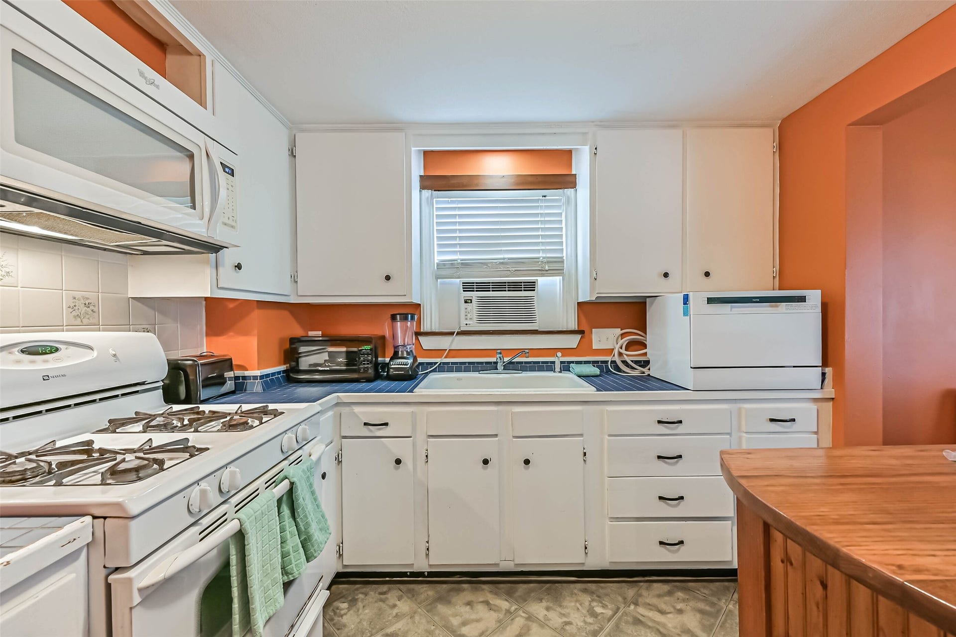 A welcoming kitchen with white cabinetry and a center island, offering a practical space for cooking and gathering.
