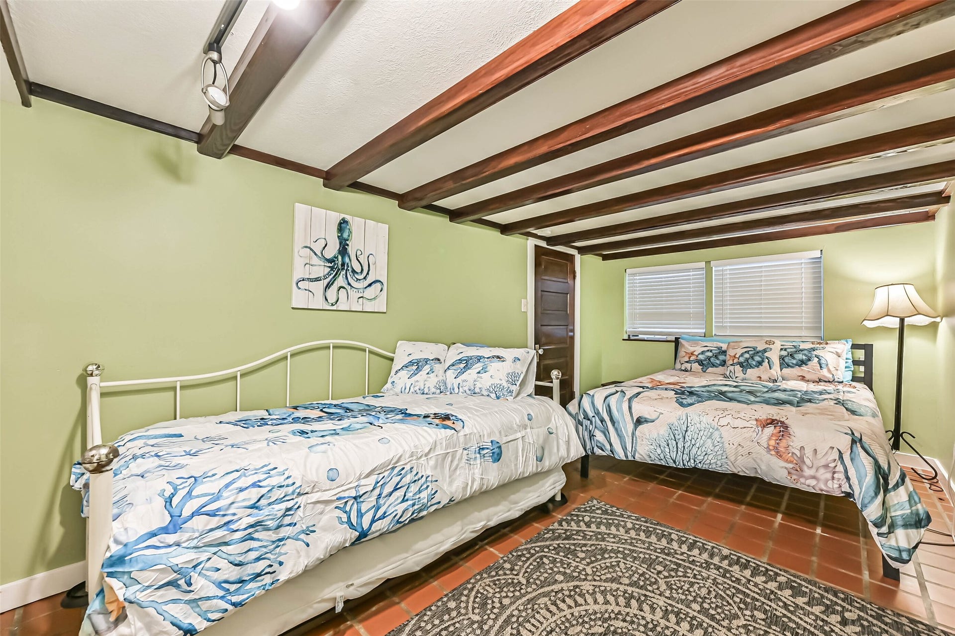 A cozy sleeping area featuring exposed ceiling beams and inviting bedding, adding rustic charm and character to the space.