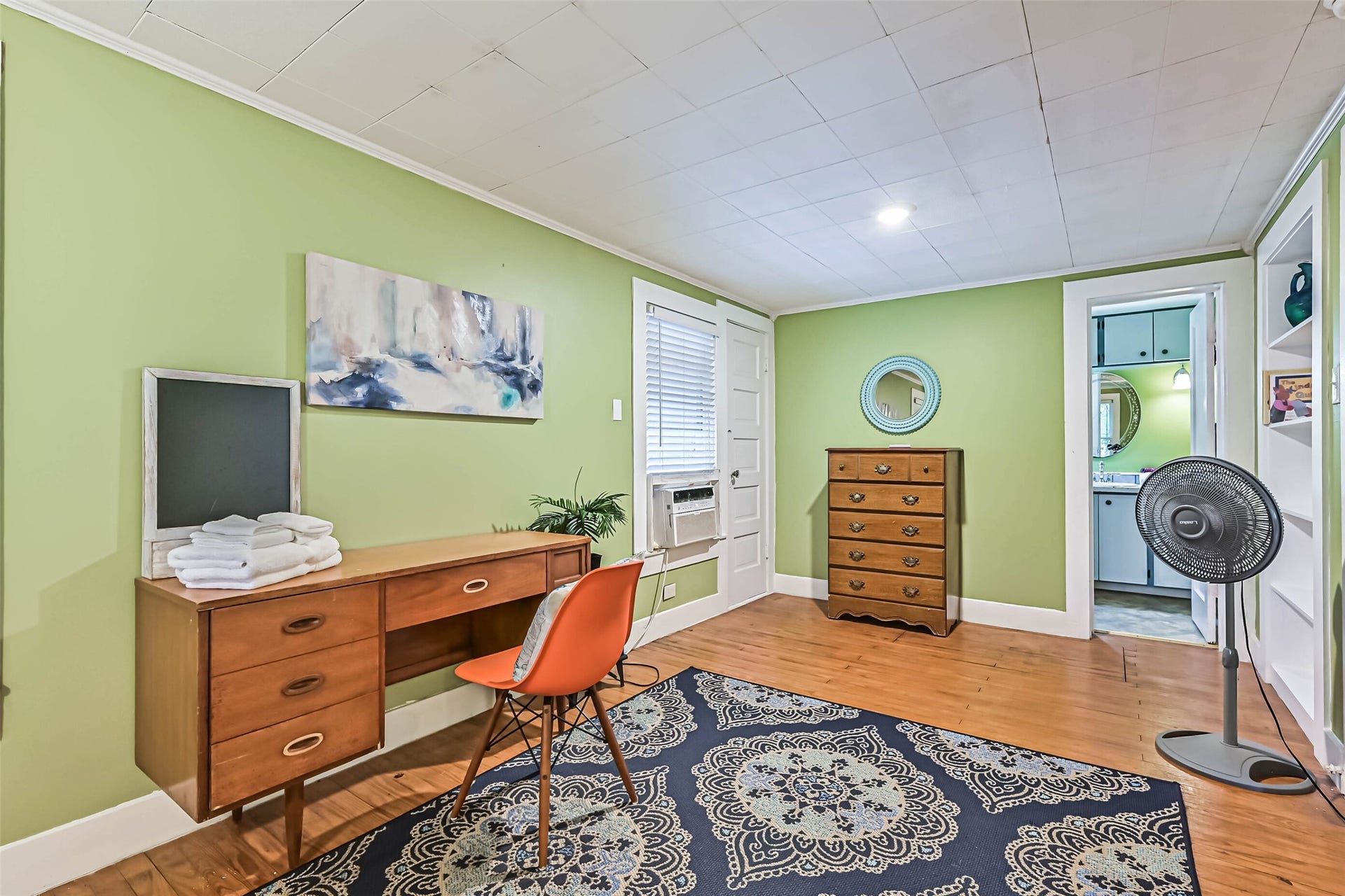 A relaxing bedroom with a comfortable bed and ceiling fan, providing a simple and inviting retreat.