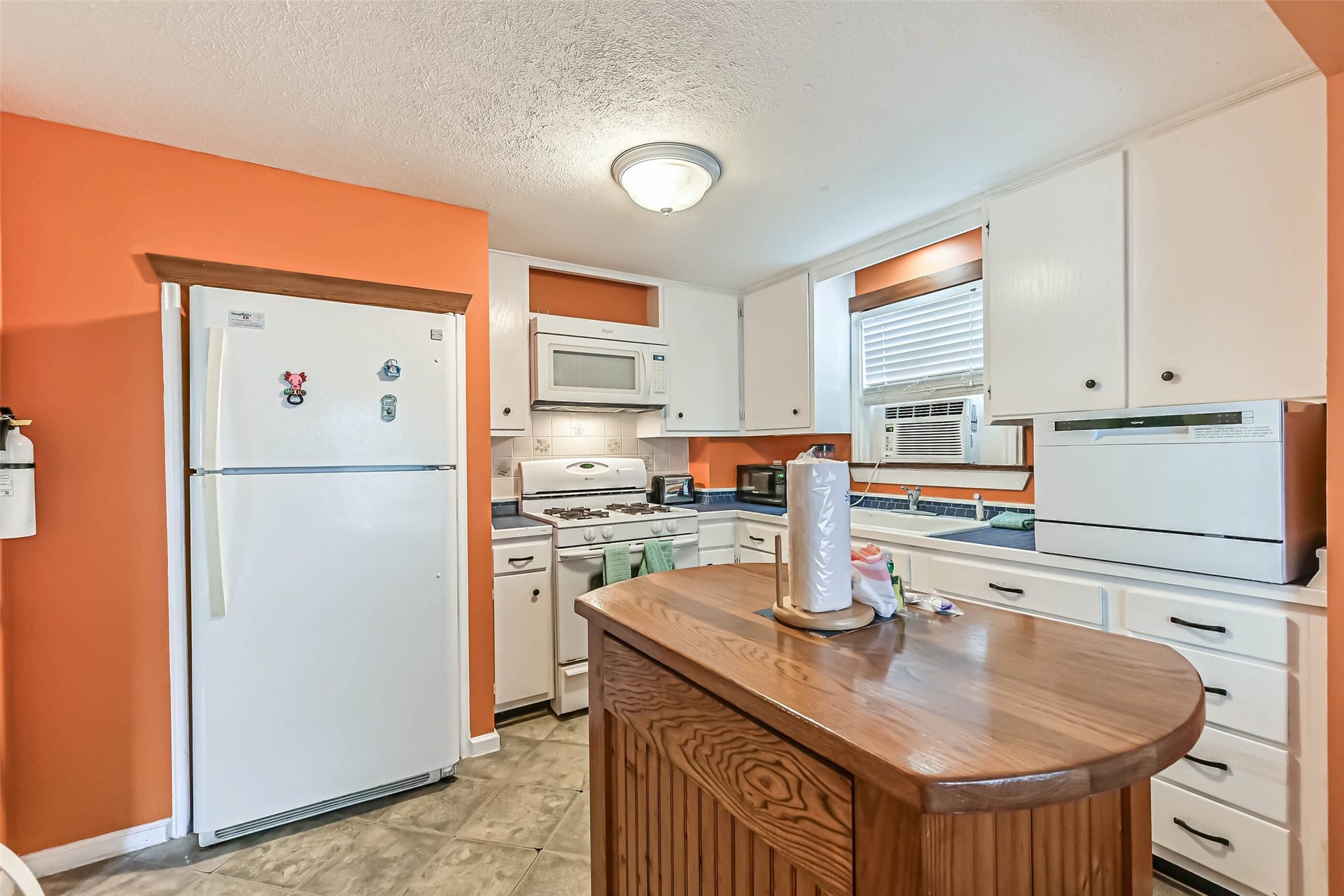 A bright kitchen with generous cabinetry and a center island, providing room to prepare meals and enjoy everyday living.