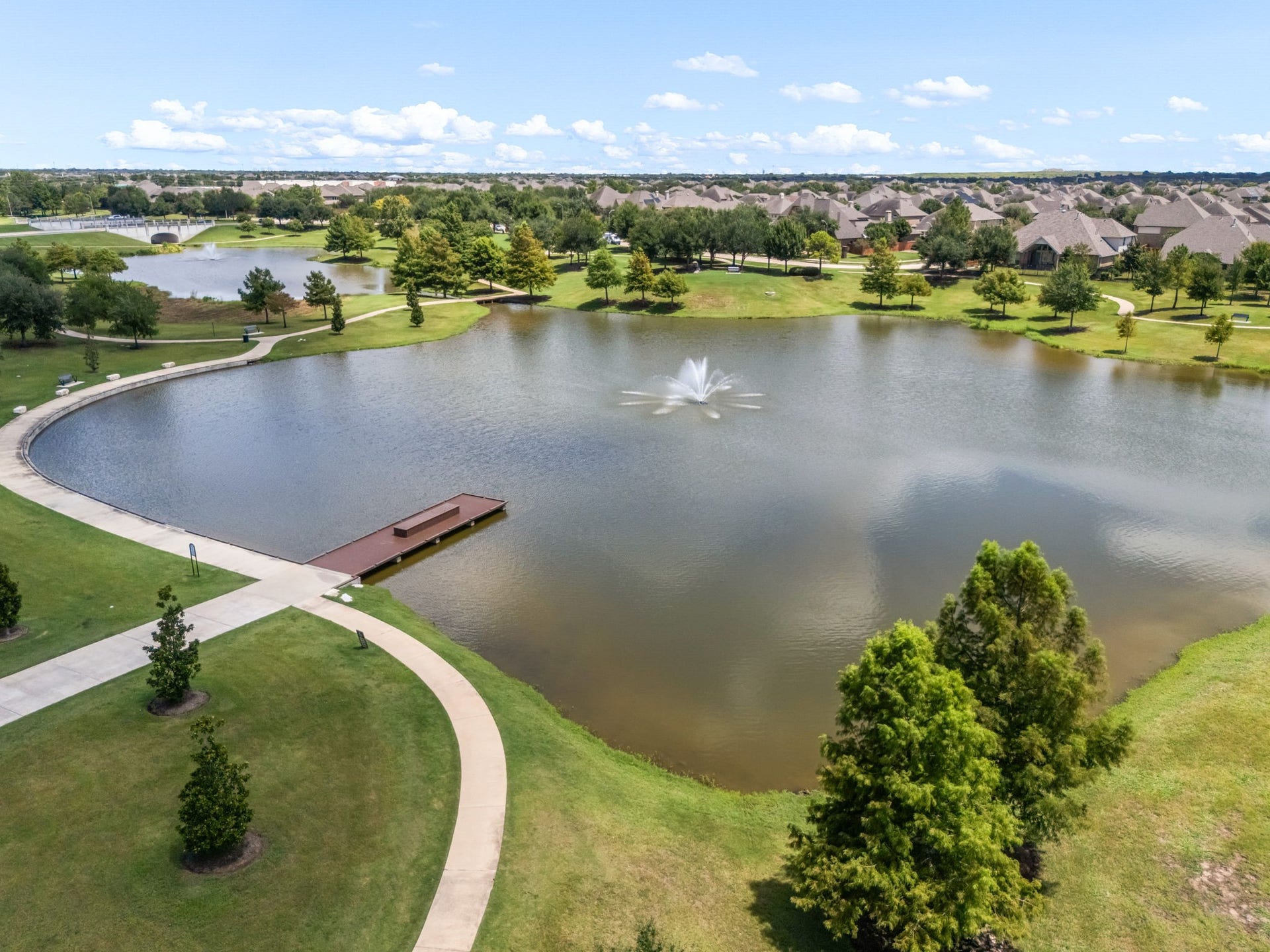 10606 Comeaux Lane, Richmond, TX 77407 Scenic water features and landscaped surroundings add to Alianas thoughtfully planned setting, creating attractive views throughout the community. The lakefront setting shown here highlights the neighborhoods emphasis on expansive outdoor spaces and a connected community design.