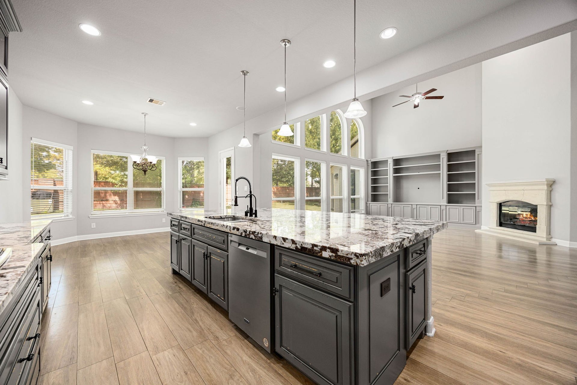 10606 Comeaux Lane, Richmond, TX 77407 The kitchen's oversized island offers abundant prep space and seating, opening directly to a sunlit breakfast nook and the two-story living area beyond ideal for both daily life and entertaining.