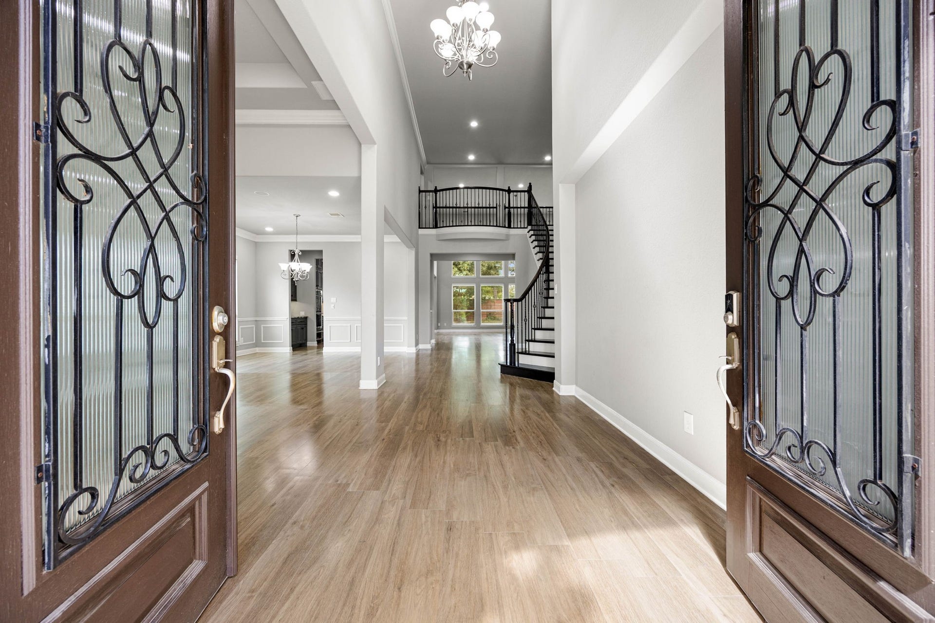 10606 Comeaux Lane, Richmond, TX 77407 A dramatic two-story foyer welcomes you in, where a wrought-iron staircase and railing wind gracefully beneath a crystal chandelier, opening directly into the home's light-filled main living spaces.