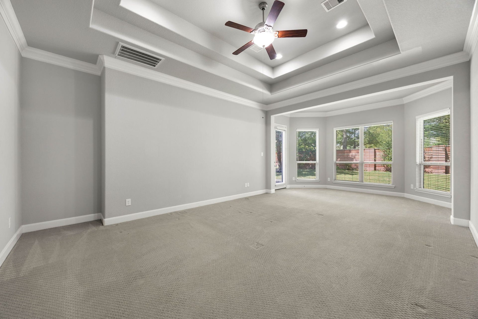 10606 Comeaux Lane, Richmond, TX 77407 One of the home's two primary suites offers a generous tray ceiling and a bright bay-window sitting area, creating a versatile retreat with room to spare.