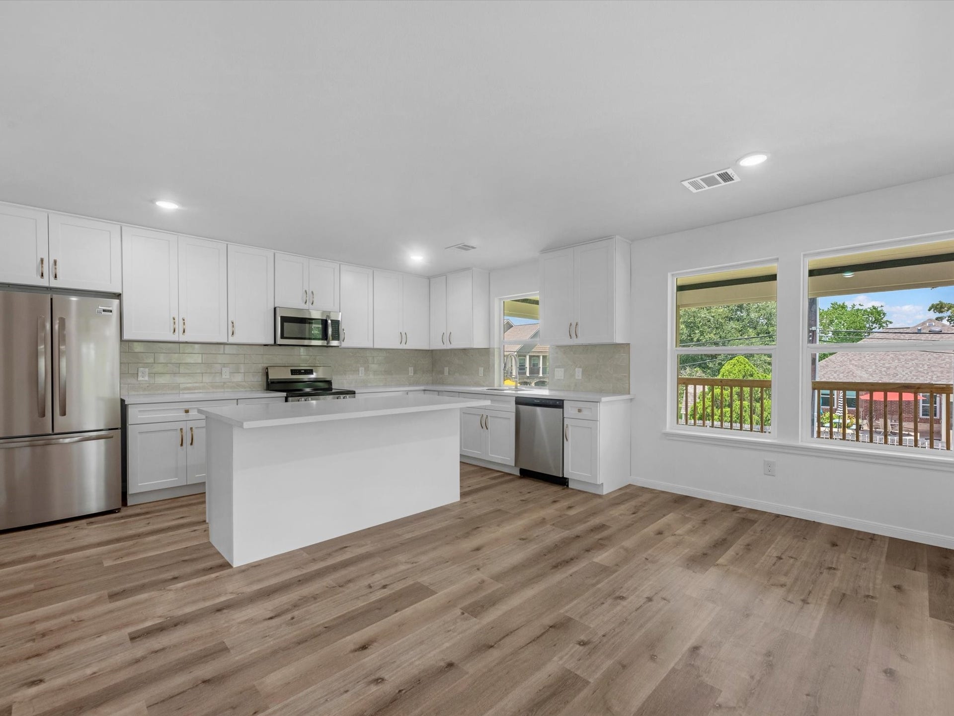 Bright and spacious open-concept kitchen and living area featuring a modern island, custom cabinetry, and elegant touches. Perfect for entertaining.