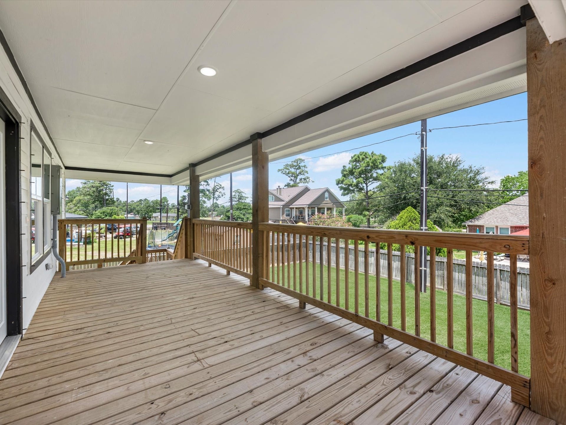 Charming Covered porch with rich white siding and ample windows, perfect for relaxing and enjoying the view.