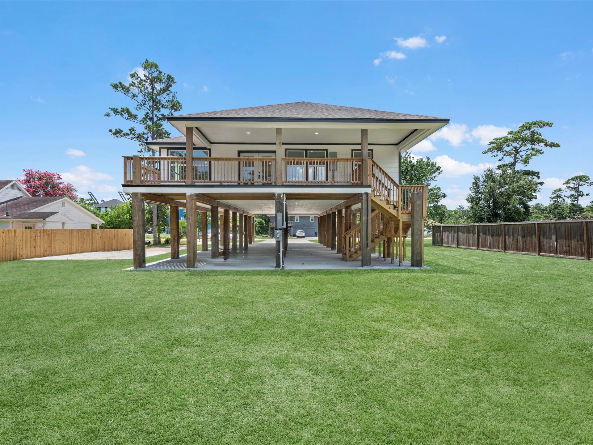 Spacious covered balcony with wooden flooring offers scenic views, perfect for relaxation.