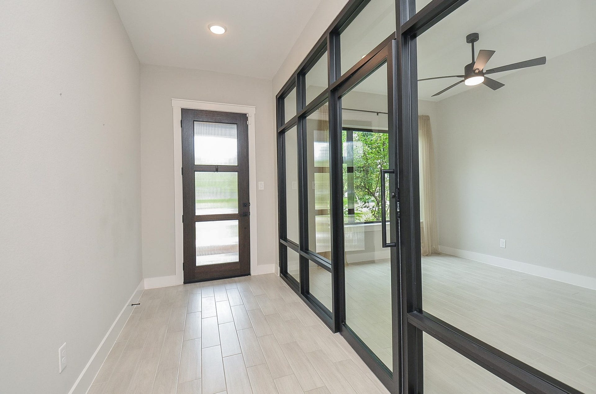 15814 Celebration Lane, Cypress, TX 77433 Statement black-framed glass doors introduce a sleek, modern element upon arrival.