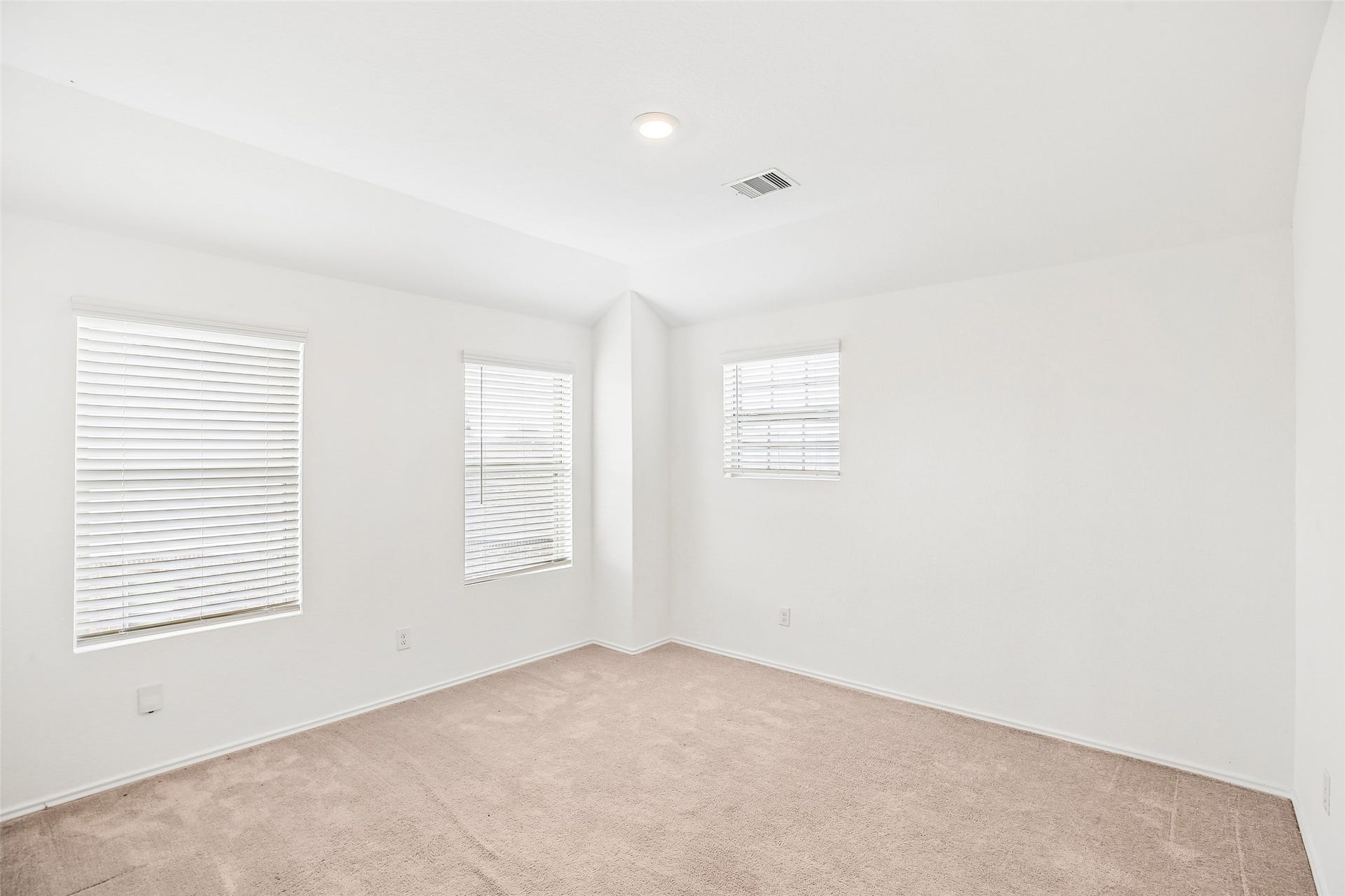 184 Kelly Street, Angleton, TX 77515 Upstairs family room with three windows, blinds, recessed lighting, and existing carpet.
