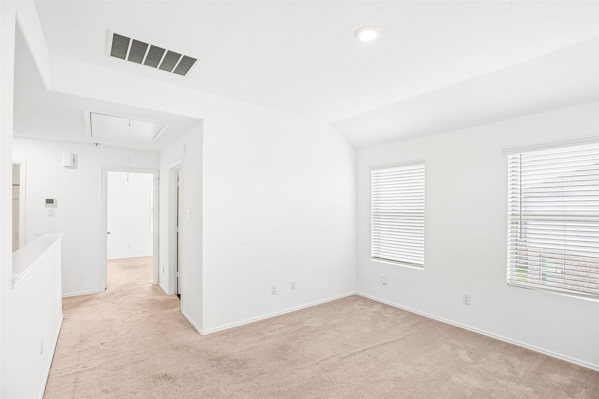 184 Kelly Street, Angleton, TX 77515 Upstairs family/flex area with two windows, existing carpet, and open access to the stair and adjacent rooms.