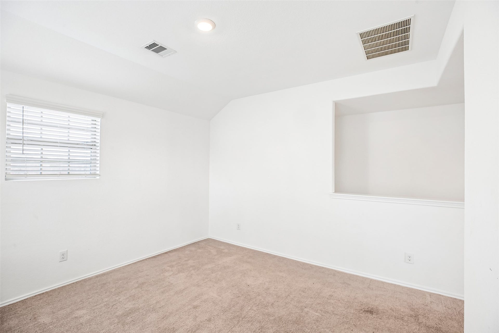 184 Kelly Street, Angleton, TX 77515 Upstairs family room with existing carpet, a window, ceiling vents, and an open stair-side half-wall.