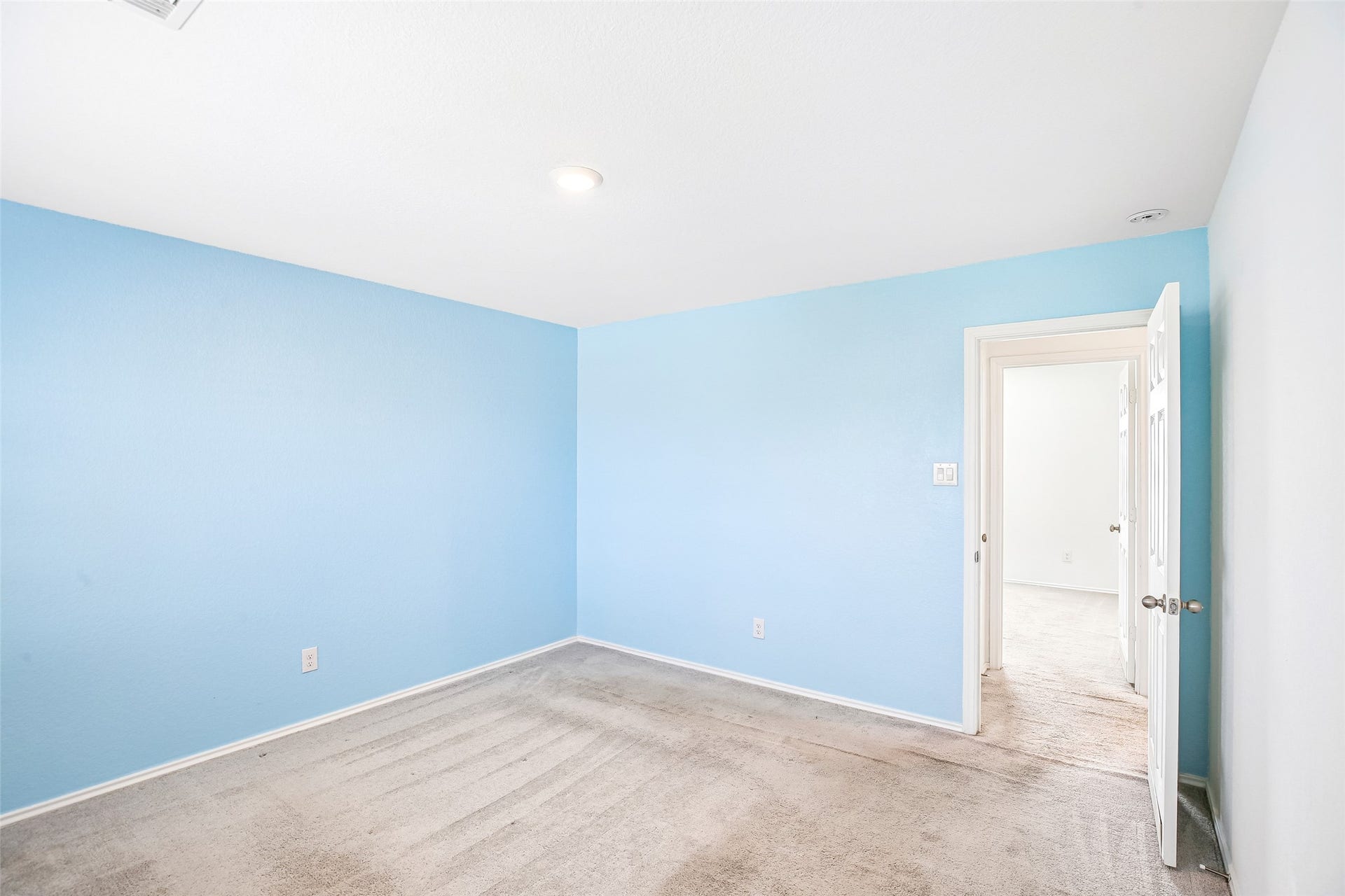 184 Kelly Street, Angleton, TX 77515 Empty carpeted room with blue-painted walls and an open doorway.