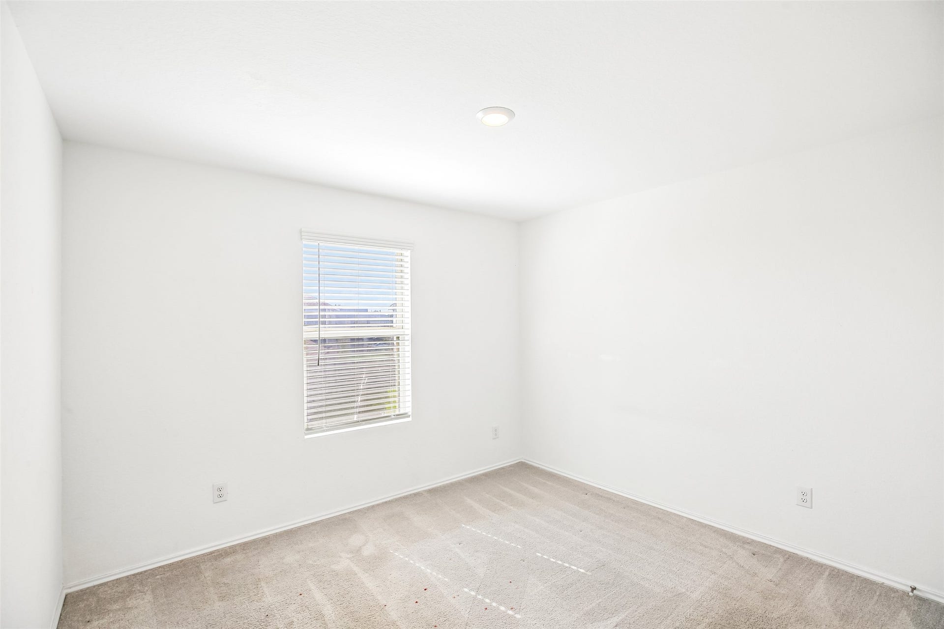 184 Kelly Street, Angleton, TX 77515 Empty carpeted interior room with a window, white blinds, recessed light, baseboards, and visible outlets.