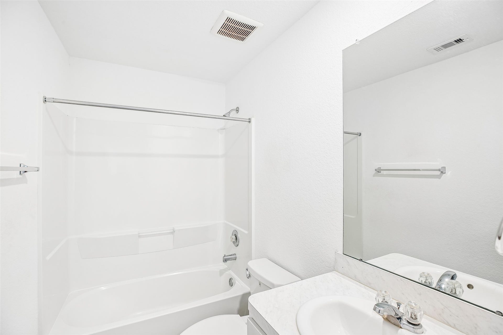 184 Kelly Street, Angleton, TX 77515 Bright bathroom with a tub/shower, vanity, mirrored wall, and neutral white finishes.
