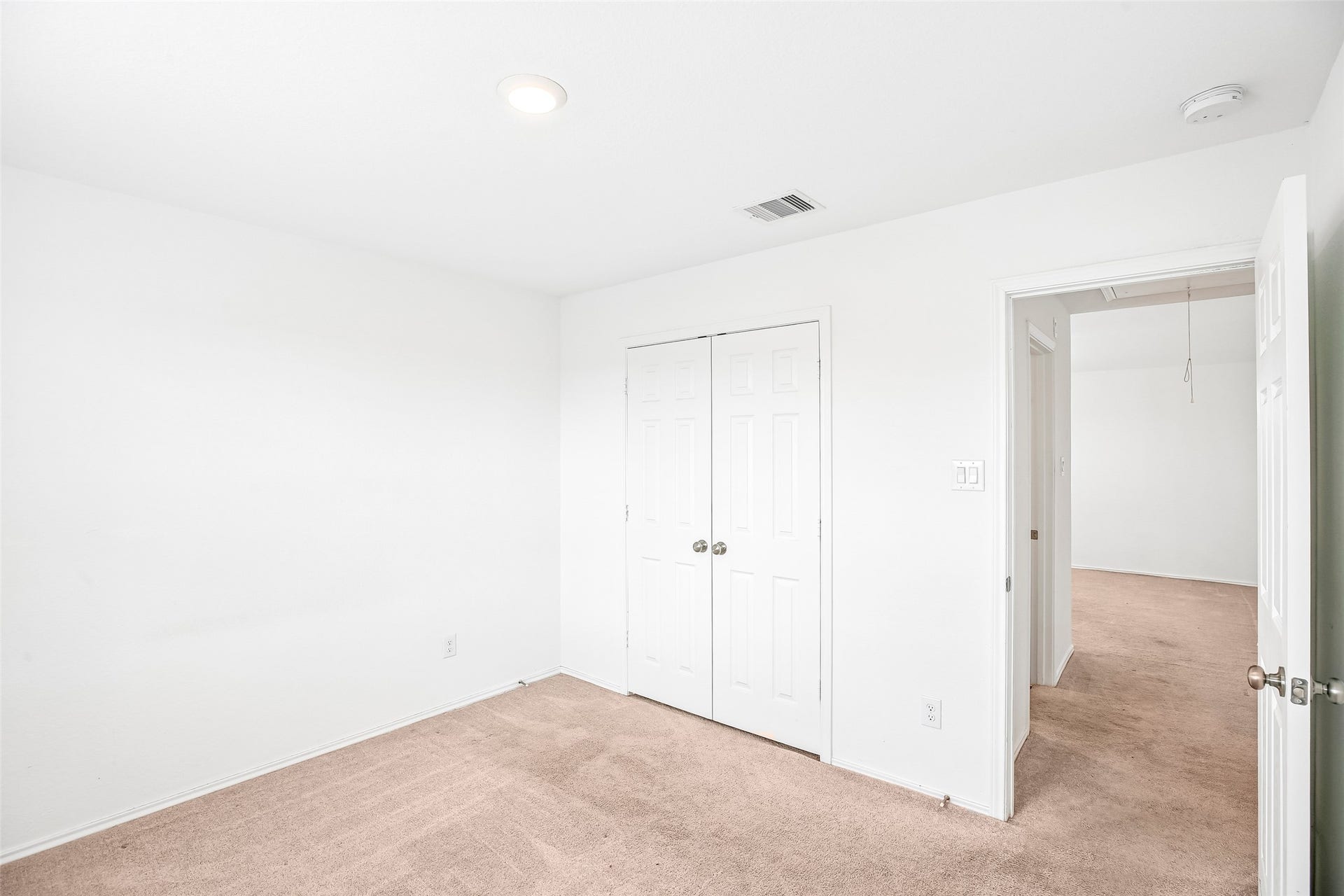 184 Kelly Street, Angleton, TX 77515 Empty carpeted room with double closet doors and an open doorway to the carpeted hall/adjacent room.