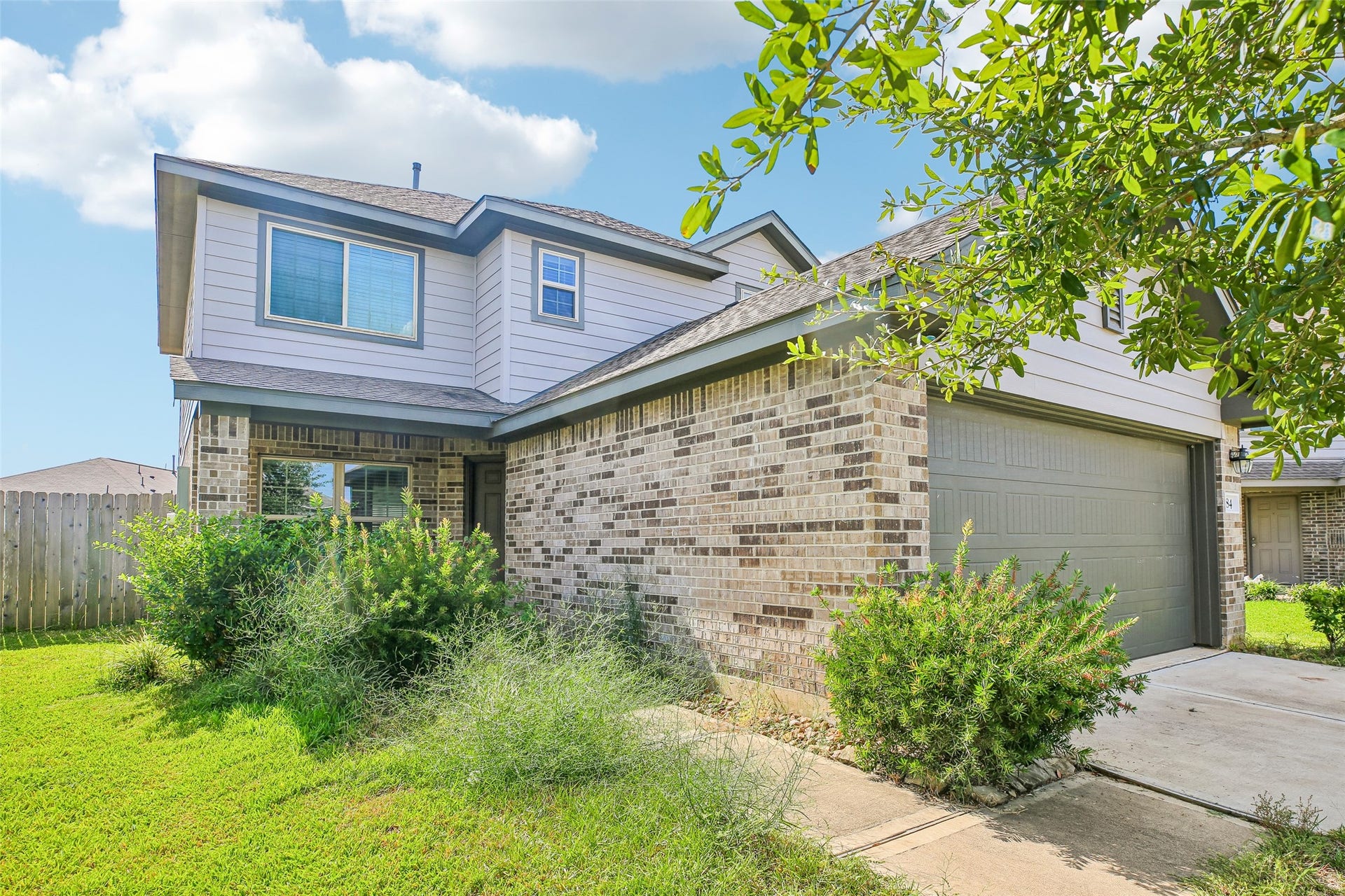 184 Kelly Street, Angleton, TX 77515 Front exterior view showing the home's brick-and-siding facade, entry, garage, driveway, and landscaped lawn.