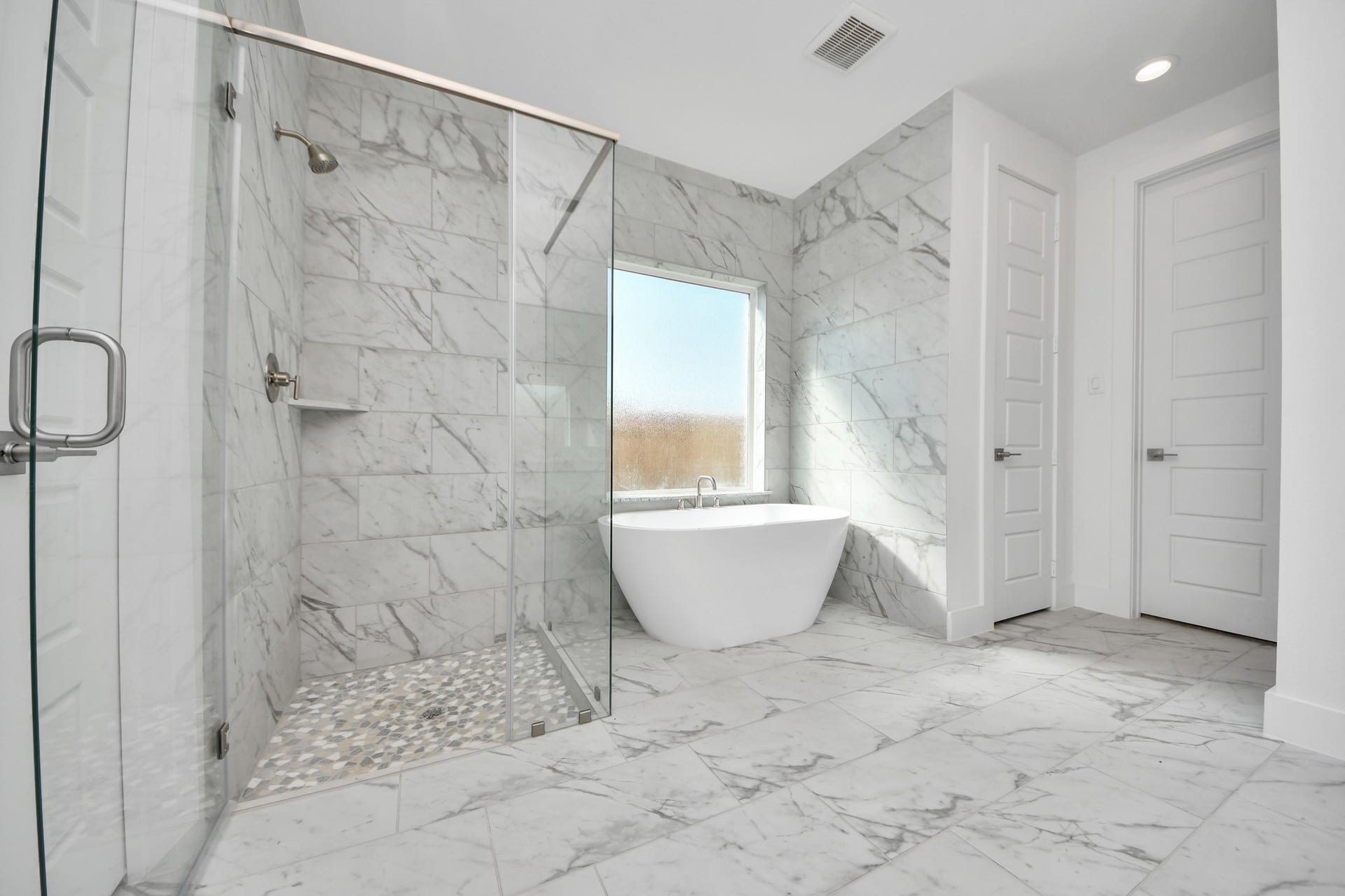Indulge in a spa-like retreat within the confines of this primary bathroom. Delight in a spacious walk-in shower enveloped in stylish tile surround, unwind in a separate garden tub adorned with custom detailing.