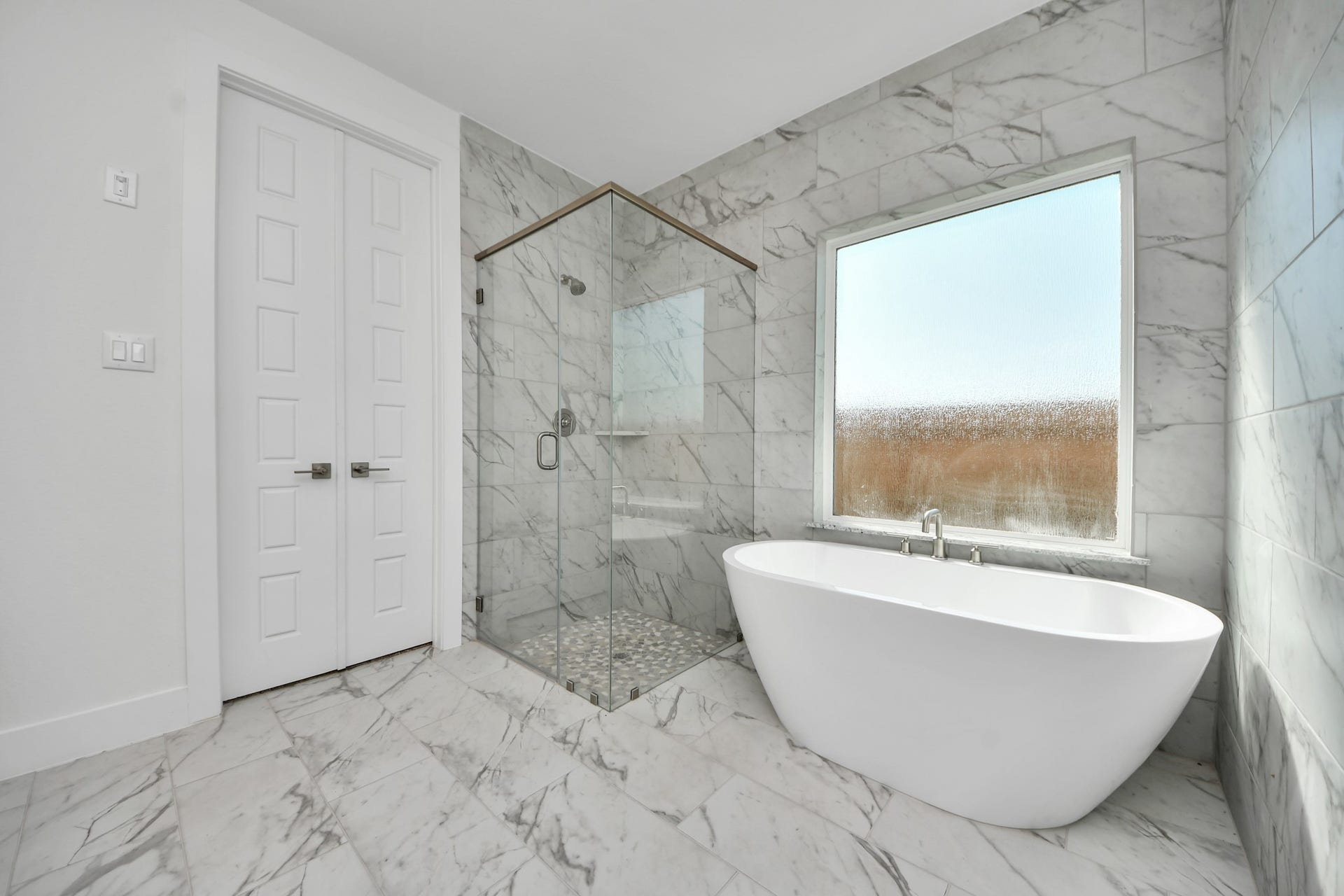 Indulge in a spa-like retreat within the confines of this primary bathroom. Delight in a spacious walk-in shower enveloped in stylish tile surround, unwind in a separate garden tub adorned with custom detailing.