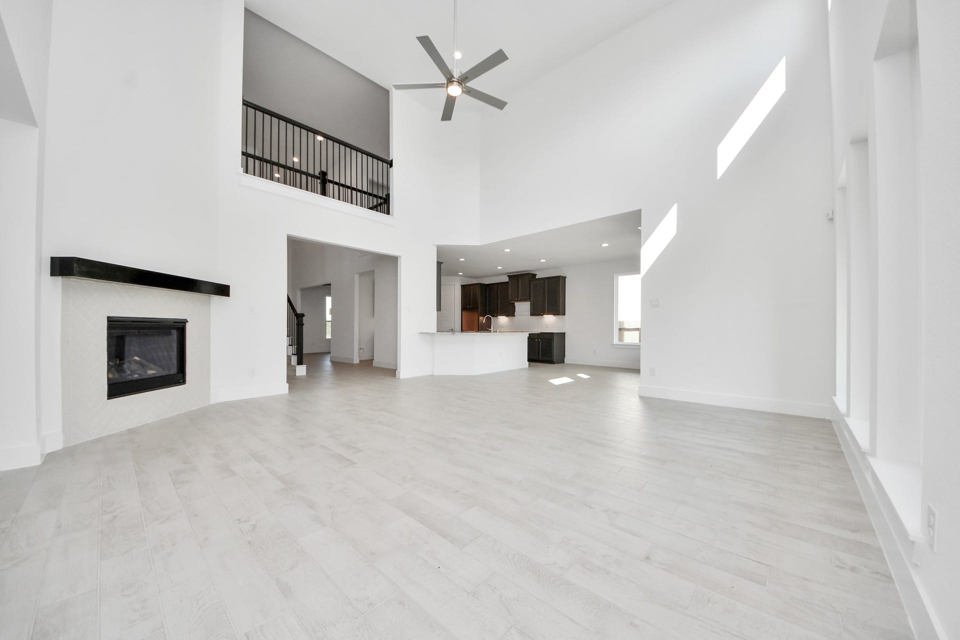 Relax and unwind in this inviting family room, illuminated by abundant natural light streaming in through tall windows, complemented by high ceilings and stunning flooring. Stay comfortable year-round with the gentle breeze from the ceiling fan, creating the perfect atmosphere for family gatherings.