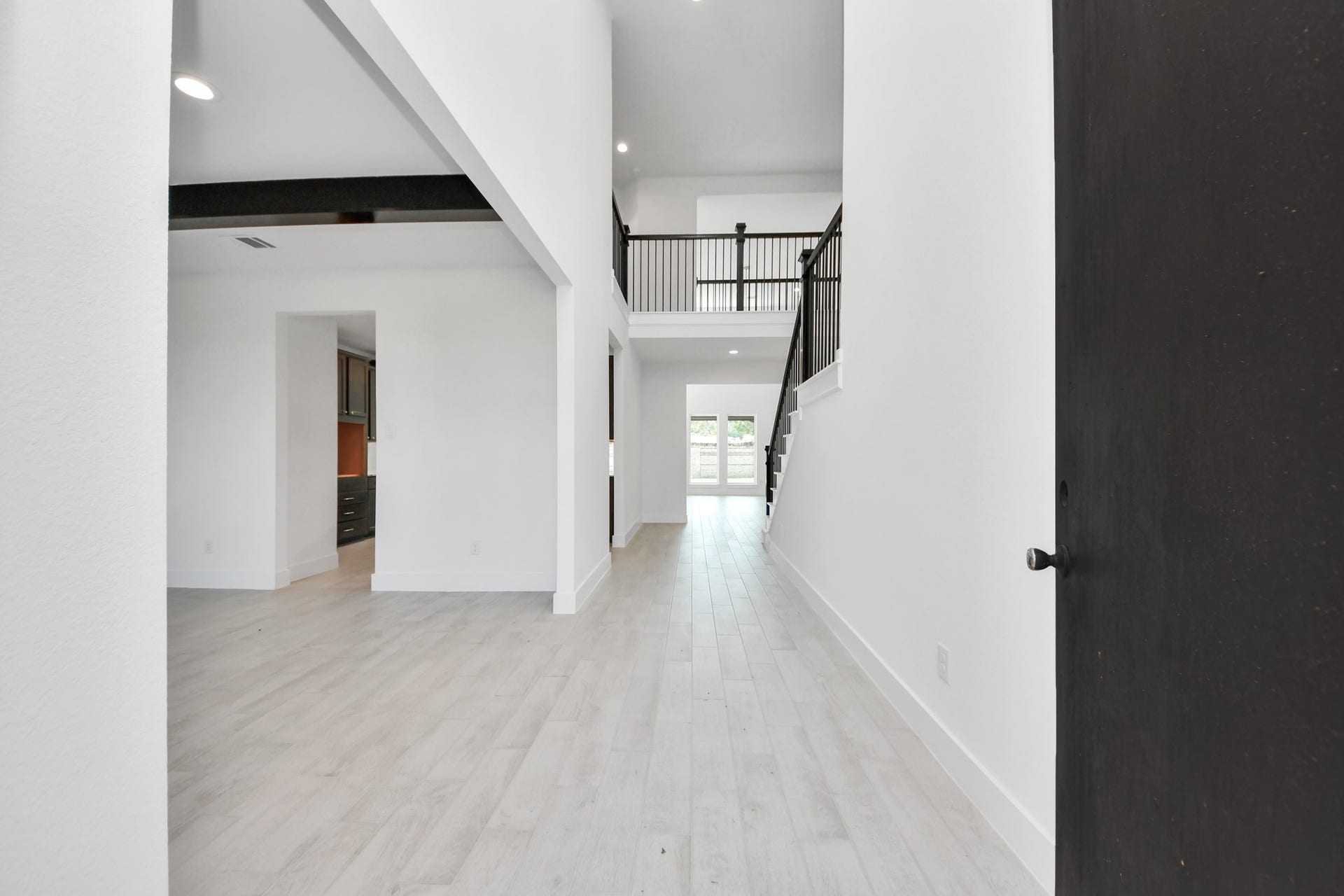 As you step into the threshold of this luxurious home, you'll soon be welcomed by an elegant glass door (to be installed). Inside, soaring ceilings amplify the spaciousness, while the refined wood-look tile flooring and oversized baseboards exude sophistication and charm.