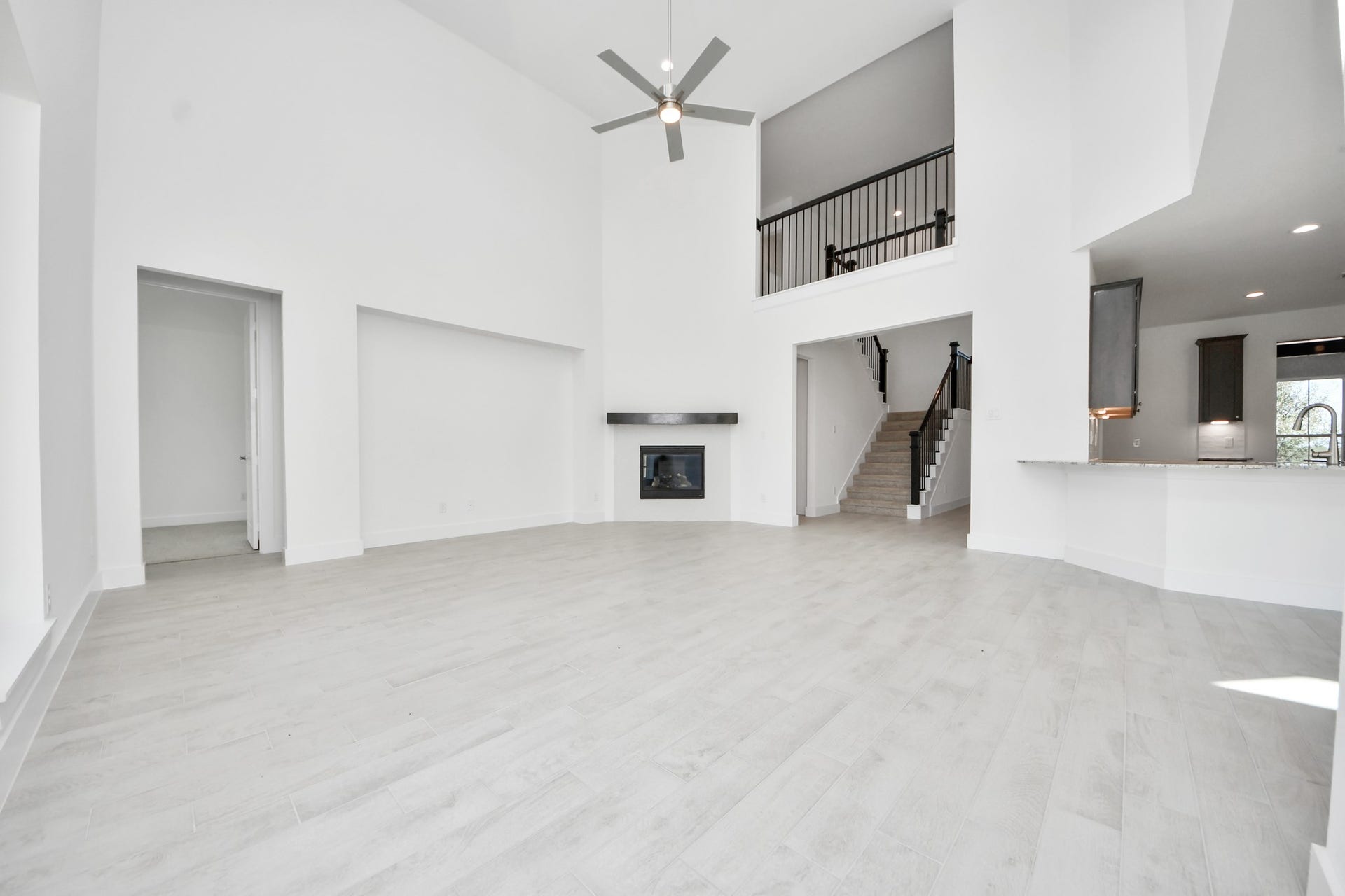 Family room flooded with natural light through the expansive windows.  The premium tile flooring adds a touch of luxury to the space, creating the perfect setting for relaxing moments and cherished gatherings with loved ones