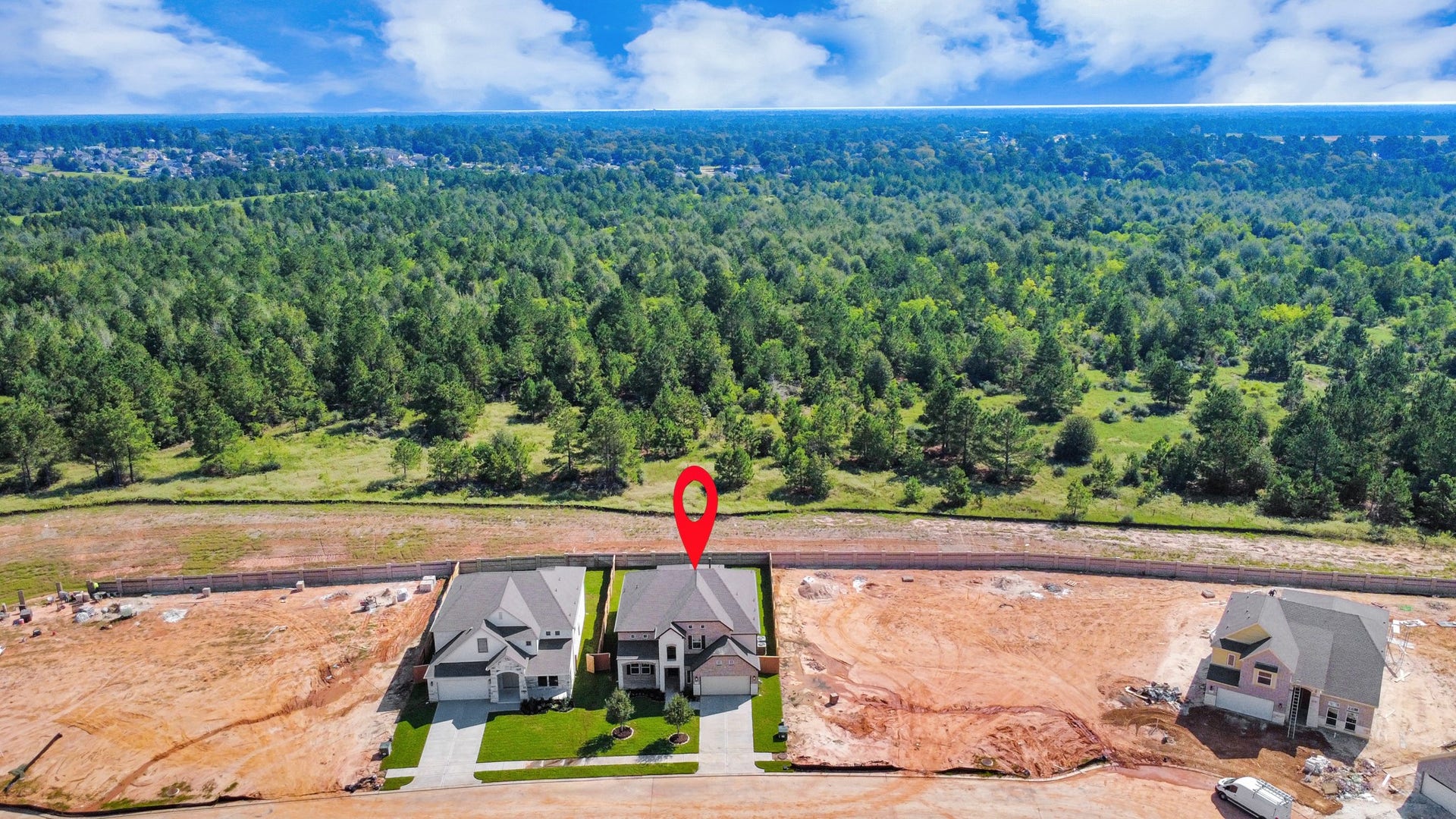 An aerial view of a spacious subdivision lot, highlighting a well-maintained yard and a fully fenced perimeter, offering both privacy and expansive outdoor space.