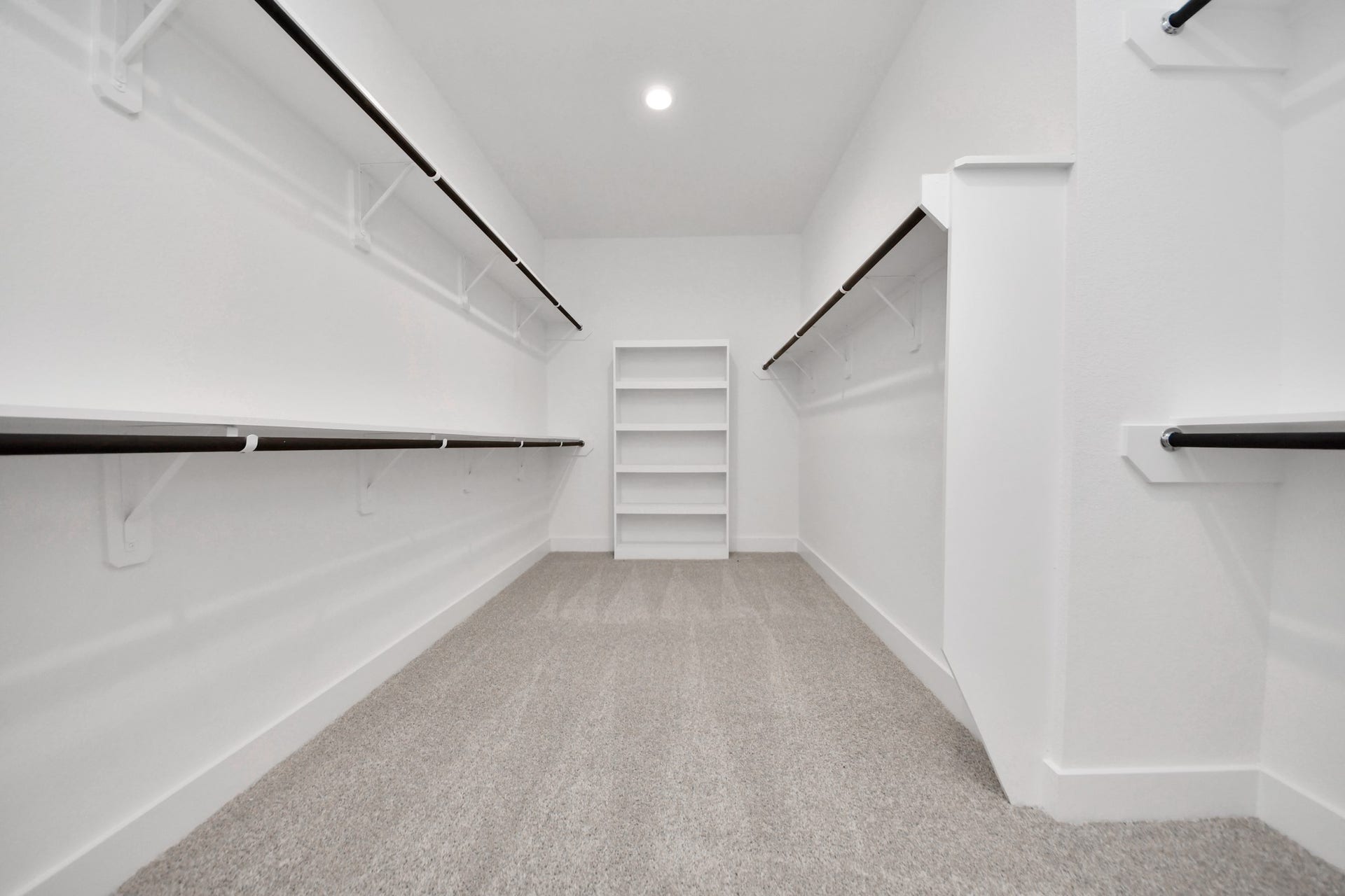 Walk-in closet that epitomizes luxury and practicality. This generously sized space features built-in shelving, offering abundant room for impeccable organization. High ceilings and recessed lighting create a bright and welcoming ambiance.