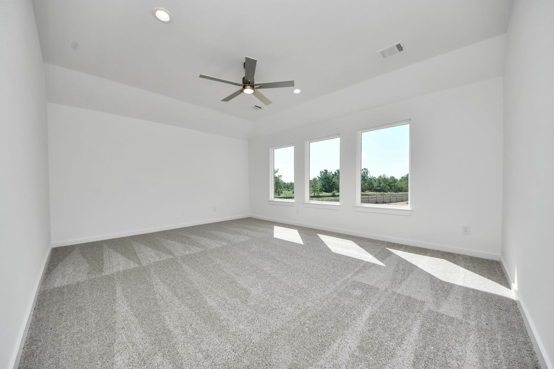 Discover a haven of leisure in this fantastic game room! Whether you're seeking a casual hangout or an adult gaming retreat, this space has it all. Enjoy the luxurious feel of plush carpet underfoot, the expansive ambiance of high ceilings, custom paint that adds a touch of personality, and windows that flood the room with refreshing natural light.