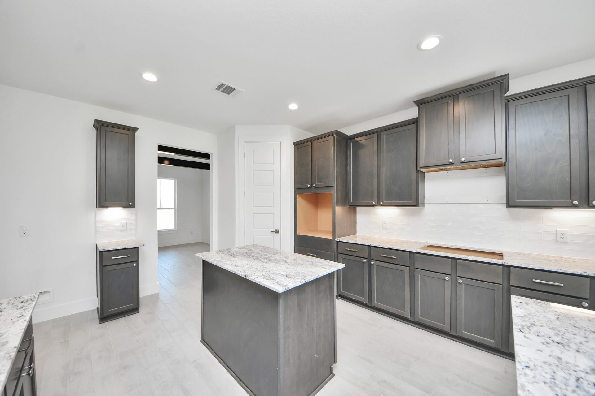 Discover another perspective of this stunning kitchen, generously appointed with an abundance of counter space