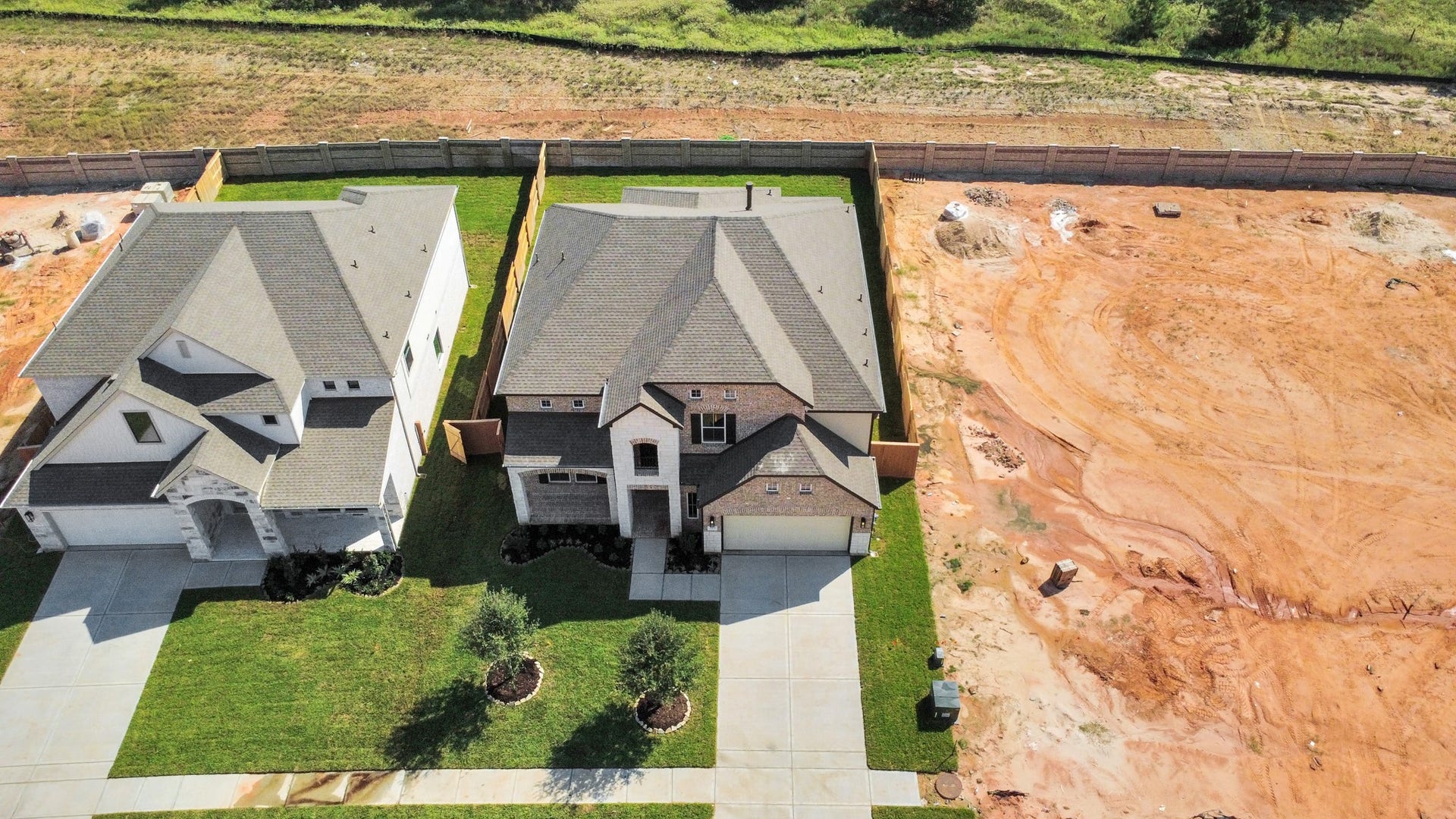 An aerial view of a spacious subdivision lot, highlighting a well-maintained yard and a fully fenced perimeter, offering both privacy and expansive outdoor space.