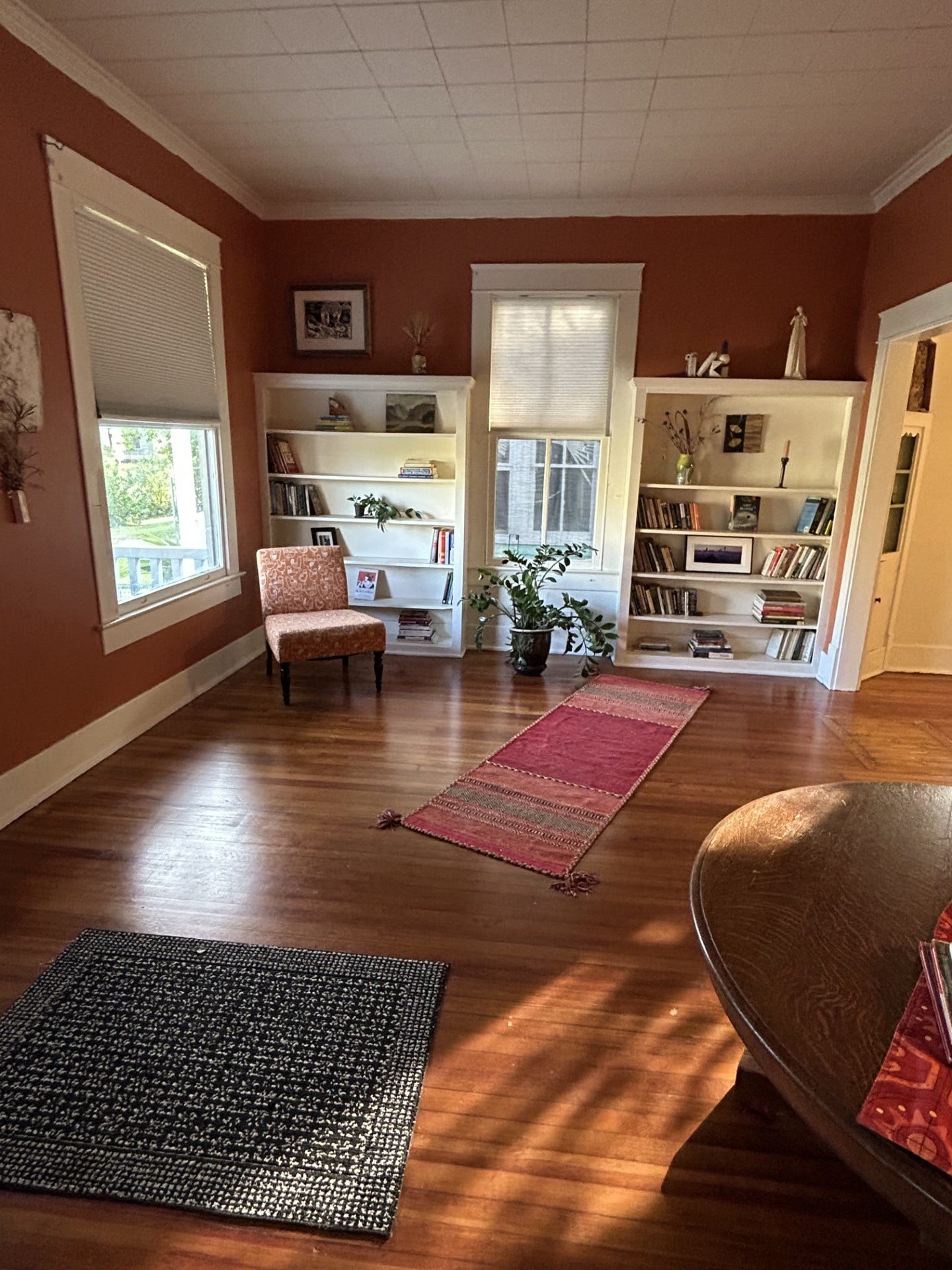 3911 Bernardo De Galvez Avenue, Galveston, TX 77550 Living room with morning natural light. Bookcases along the east side. Quartersawn original longleaf pine floors. Dining room to the right.