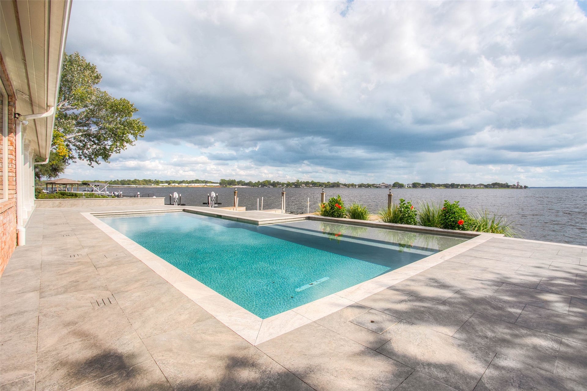 12092 Sagittarius Drive E, Willis, TX 77318 Stunning waterfront retreat featuring an elegant pool with expansive lake views, perfect for relaxing and entertaining.