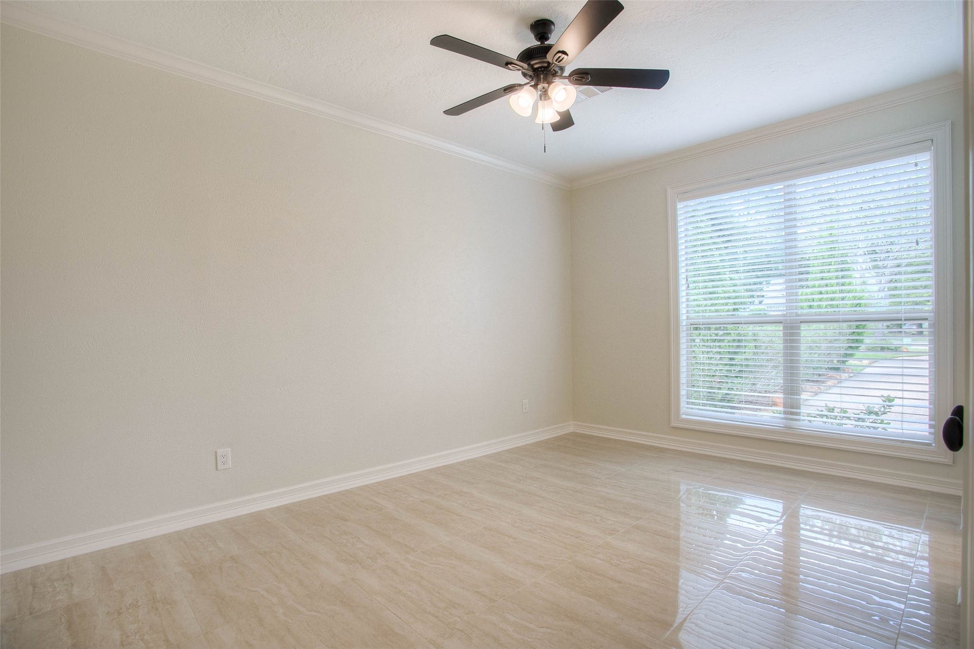 12092 Sagittarius Drive E, Willis, TX 77318 Bright and inviting, this guest bedroom features elegant flooring, abundant natural light through a large window, and a chic ceiling fan for ultimate comfort.