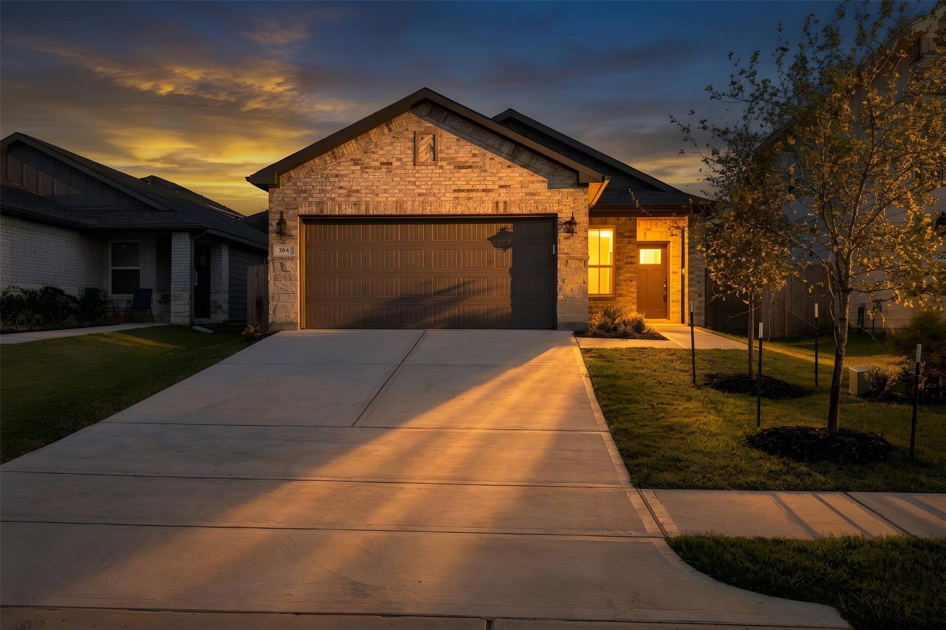 384 Sunrise Ranch Dr, Montgomery, TX 77316 Charming single-story home with a welcoming facade, featuring a spacious driveway, a two-car garage, and a cozy front entrance illuminated by warm evening lights.