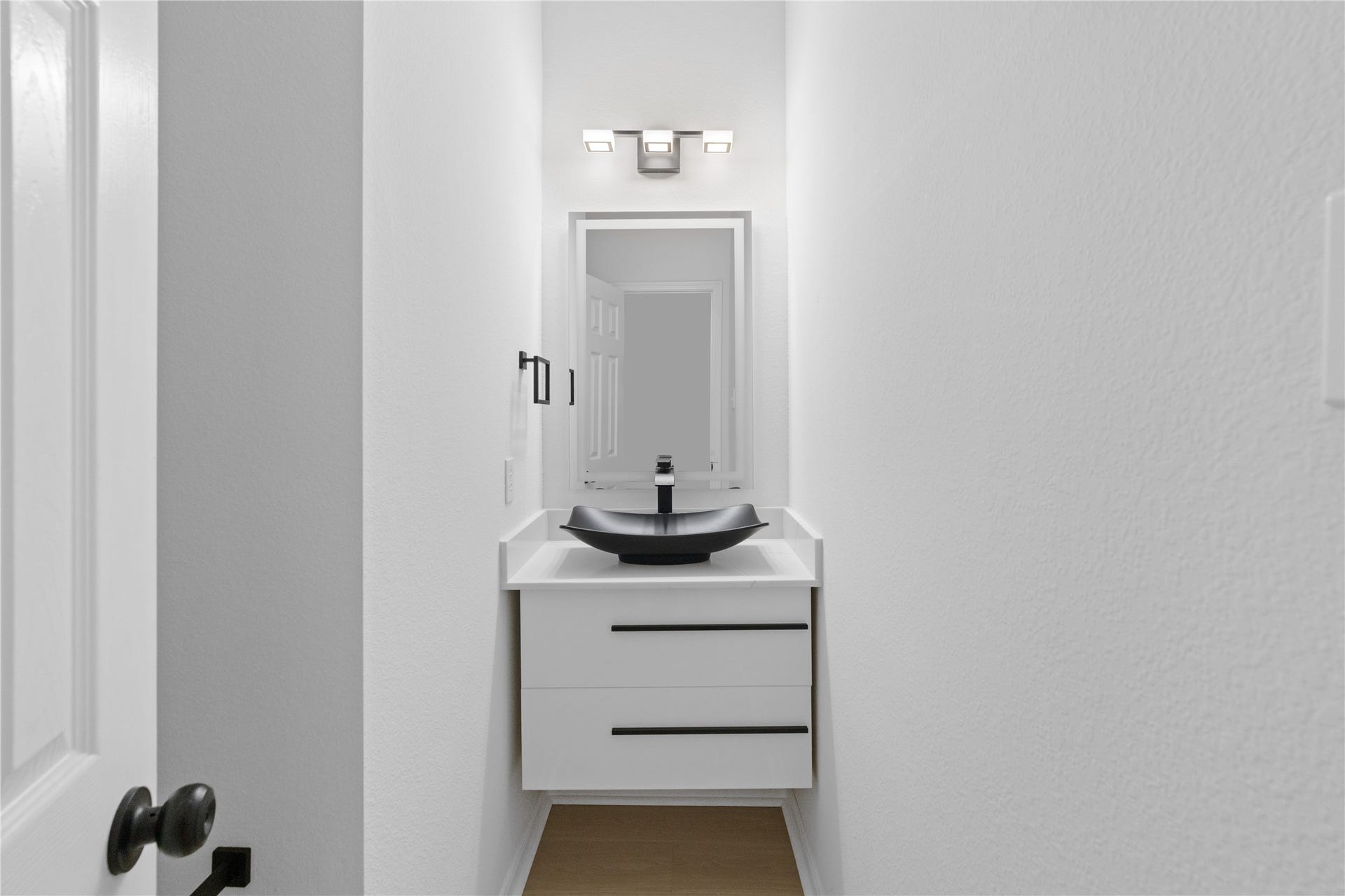 21611 Manitou Falls Lane, Katy, TX 77449 Powder Room Sleek powder room with a floating-style vanity, vessel sink, modern rectangular mirror, and contrasting black fixtures.