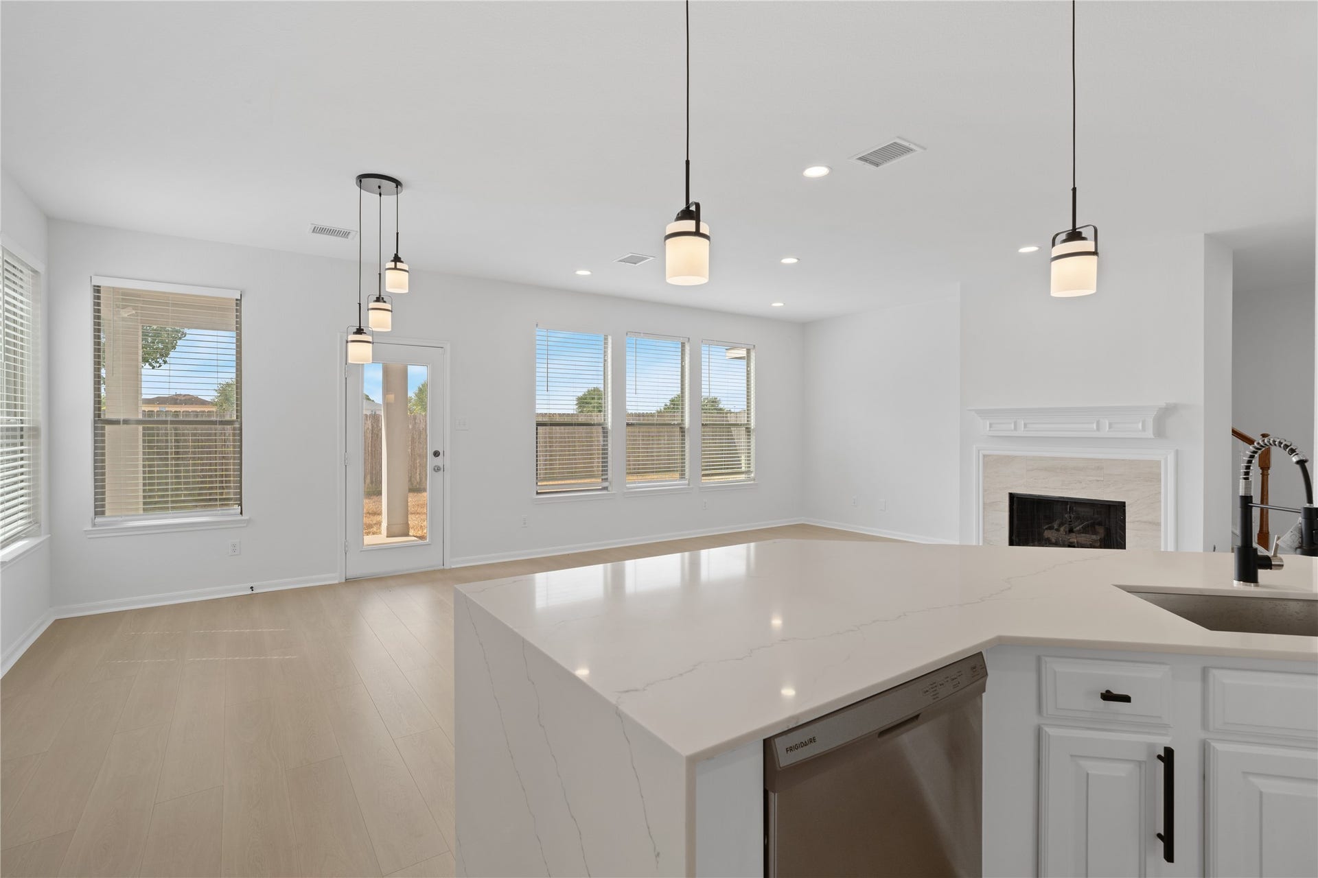 21611 Manitou Falls Lane, Katy, TX 77449 Kitchen & Living Area Large peninsula provides expansive prep and serving space while maintaining an open view toward the fireplace, dining area, and backyard-facing windows.